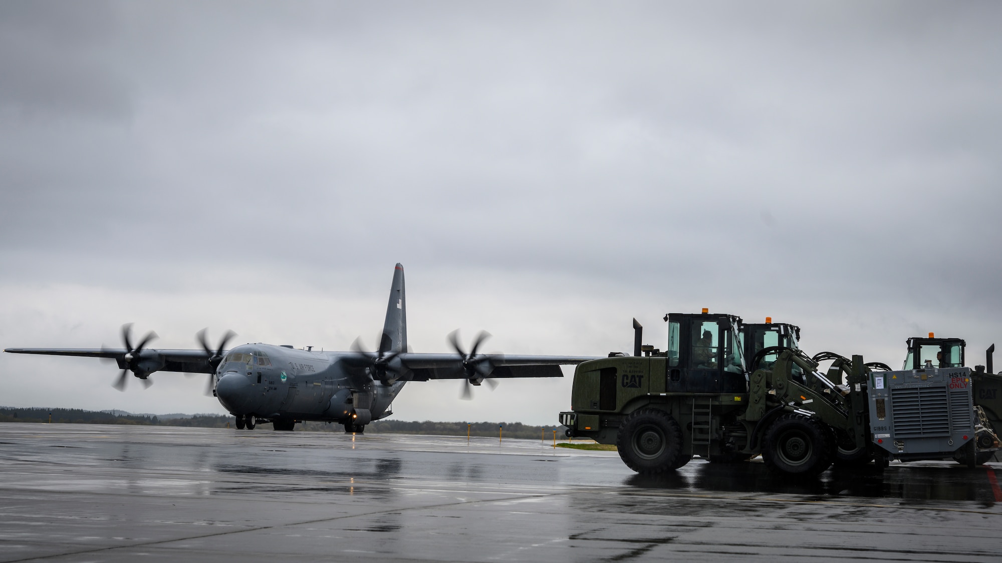 35th Logistics Readiness Squadron personnel wait to load cargo as a C-130J Super Hercules from the 374th Airlift Wing taxis down the flightline during the Beverly Sunrise 21-05 Readiness Exercise at Misawa Air Base, Japan, May 2, 2021. The C-130s are transporting cargo and personnel to support the 35th Fighter Wing’s Agile Combat Employment capabilities. (U.S. Air Force photo by Airman 1st Class China M. Shock)