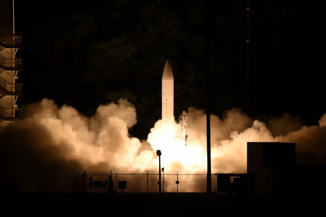 A missile launches at night in a cloud of fire and smoke.