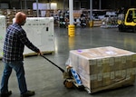 Chris Orth, a production control worker at Defense Logistics Agency Susquehanna in New Cumberland, Pennsylvania, transports the initial shipment of children’s cloth masks April 9, 2021, as part of a White House effort to deliver 25 million masks to food banks and community health centers.