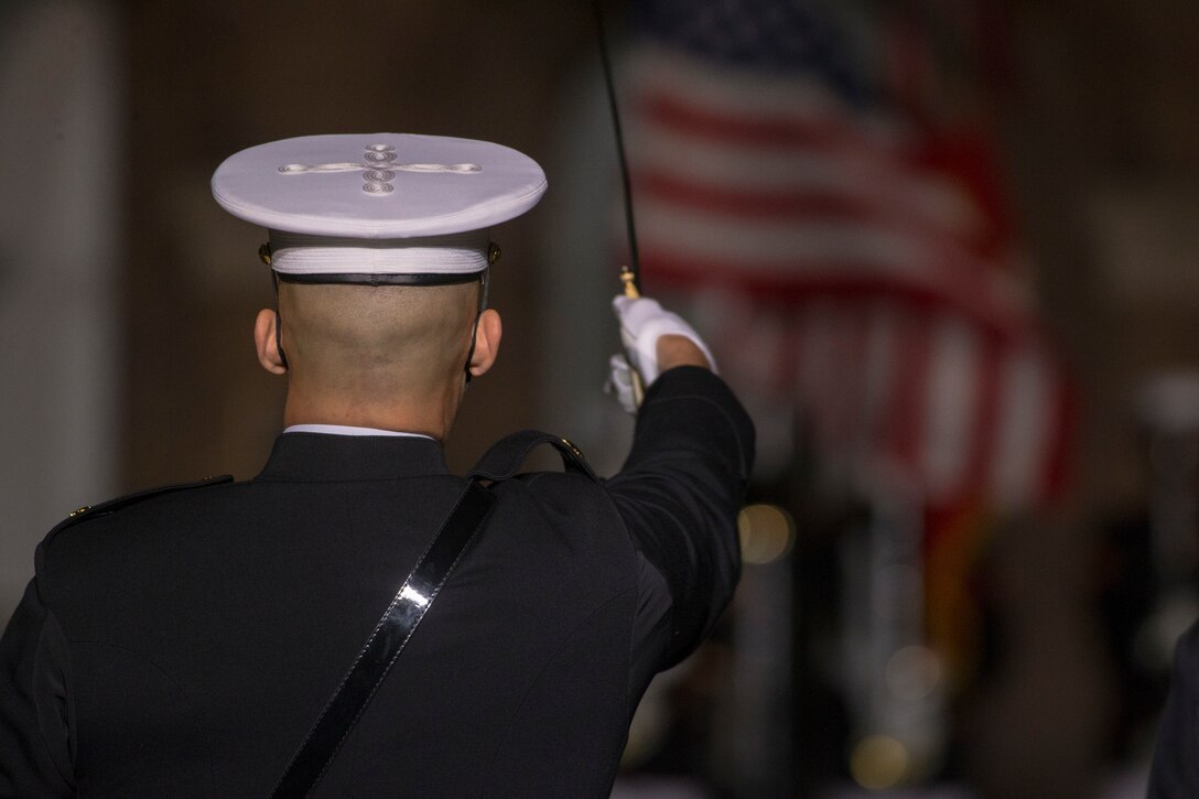 Major Alec Pourteau, parade commander, executes “draw sword” during the Friday Evening Parade at Marine Barracks Washington, D.C., April 30, 2021.