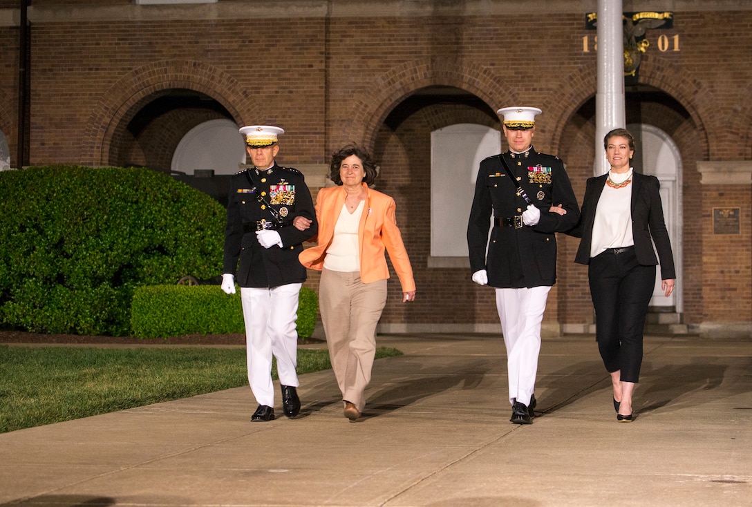 General David H. Berger, 38th Commandant of the Marine Corps, and Col. Teague A. Pastel, commanding officer, Marine Barracks Washington, walk down Center Walk with their wives during the Friday Evening Parade at Marine Barracks Washington, D.C., April 30, 2021. Pastel was the hosting official, and Gen. Berger was the guest of honor. (U.S. Marine Corps photo by Lance Cpl. Allen Sanders)