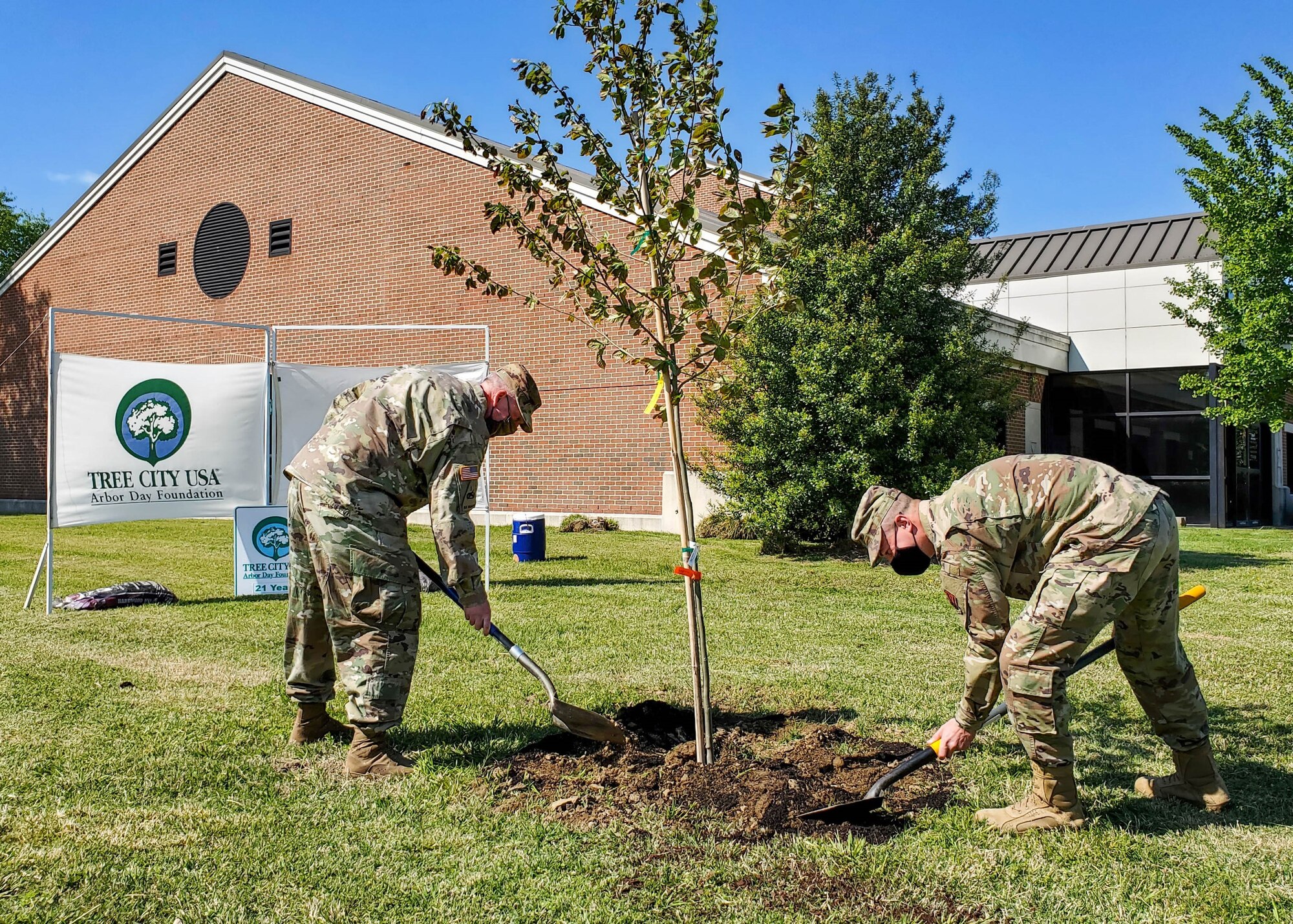Joint Base Langley-Eustis leadership plants a tree in honor of Arbor Day in front of the Bateman Library at JBLE, Virginia, April 23, 2021.