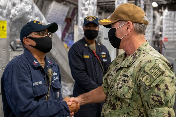 Vice Adm. Roy Kitchener, Commander, Naval Surface Forces, U.S. Pacific Fleet, right, presents a coin to Engineman 1st Class Jose Dondonaye, a Sailor assigned to the Independence-variant littoral combat ship USS Gabrielle Giffords (LCS 10).