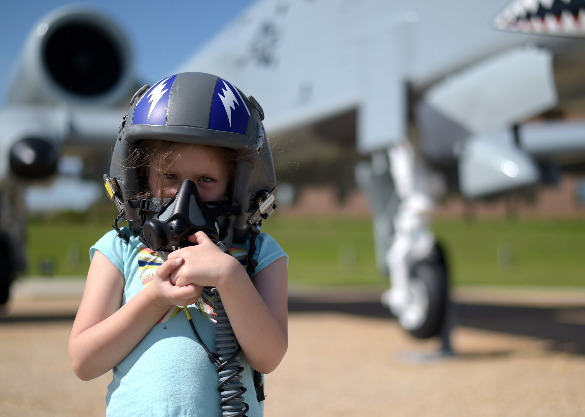 Girl in helmet in front of A-10 attack aircraft