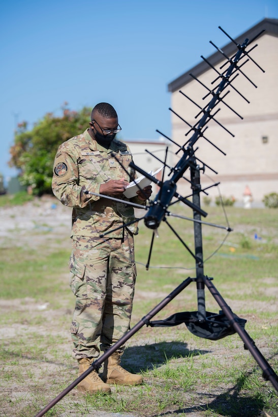 A service member sets up a satellite.