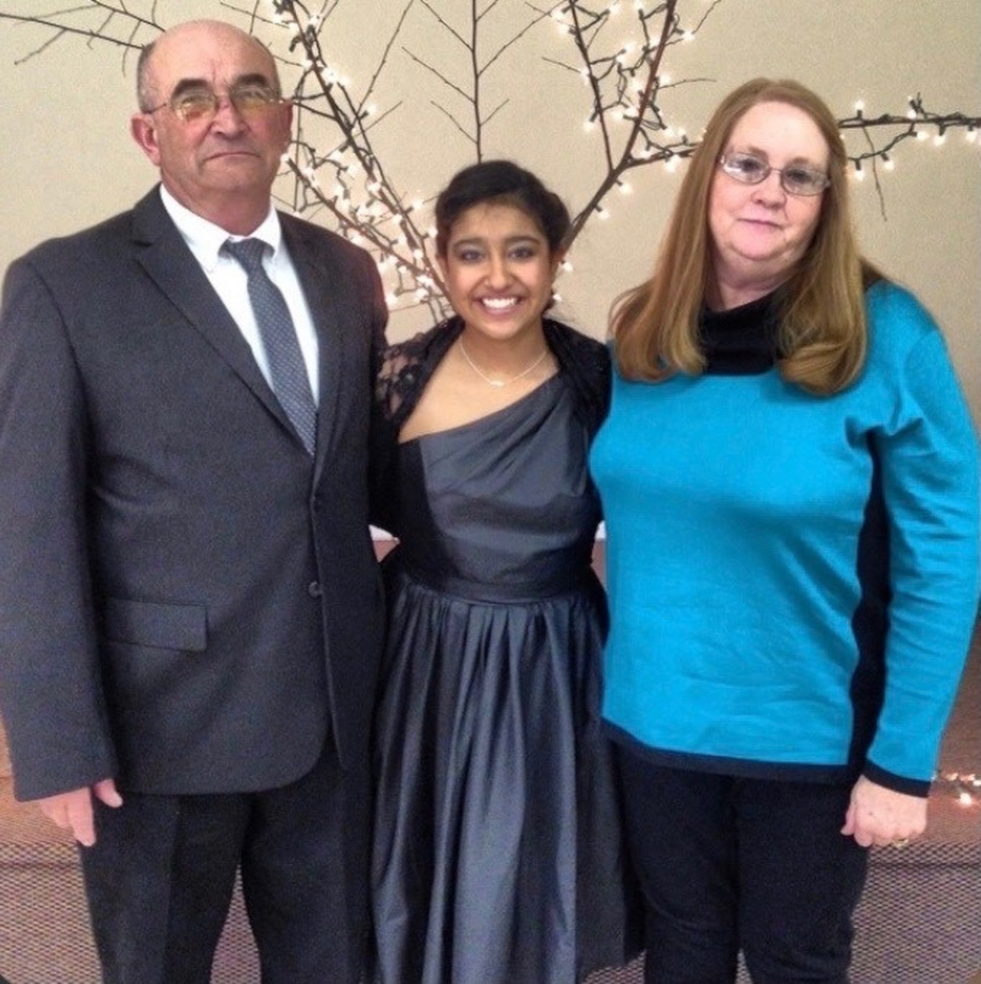 Airman 1st Class Jessica Makenna Martinez Greenlee, 36th Force Support Squadron services journeyman, poses for a photo at her niece’s wedding with her parents, Lonny and Donna Greenlee at Spartanburg, South Carolina, Feb. 16, 2014. Greenlee was placed in foster care at the age of three with three of her siblings. After being in a few homes, a couple from Lubbock, Texas showed interest in adopting all four of them, giving them the chance to grow up together with the company of 19 other children they had and adopted. (Courtesy photo)