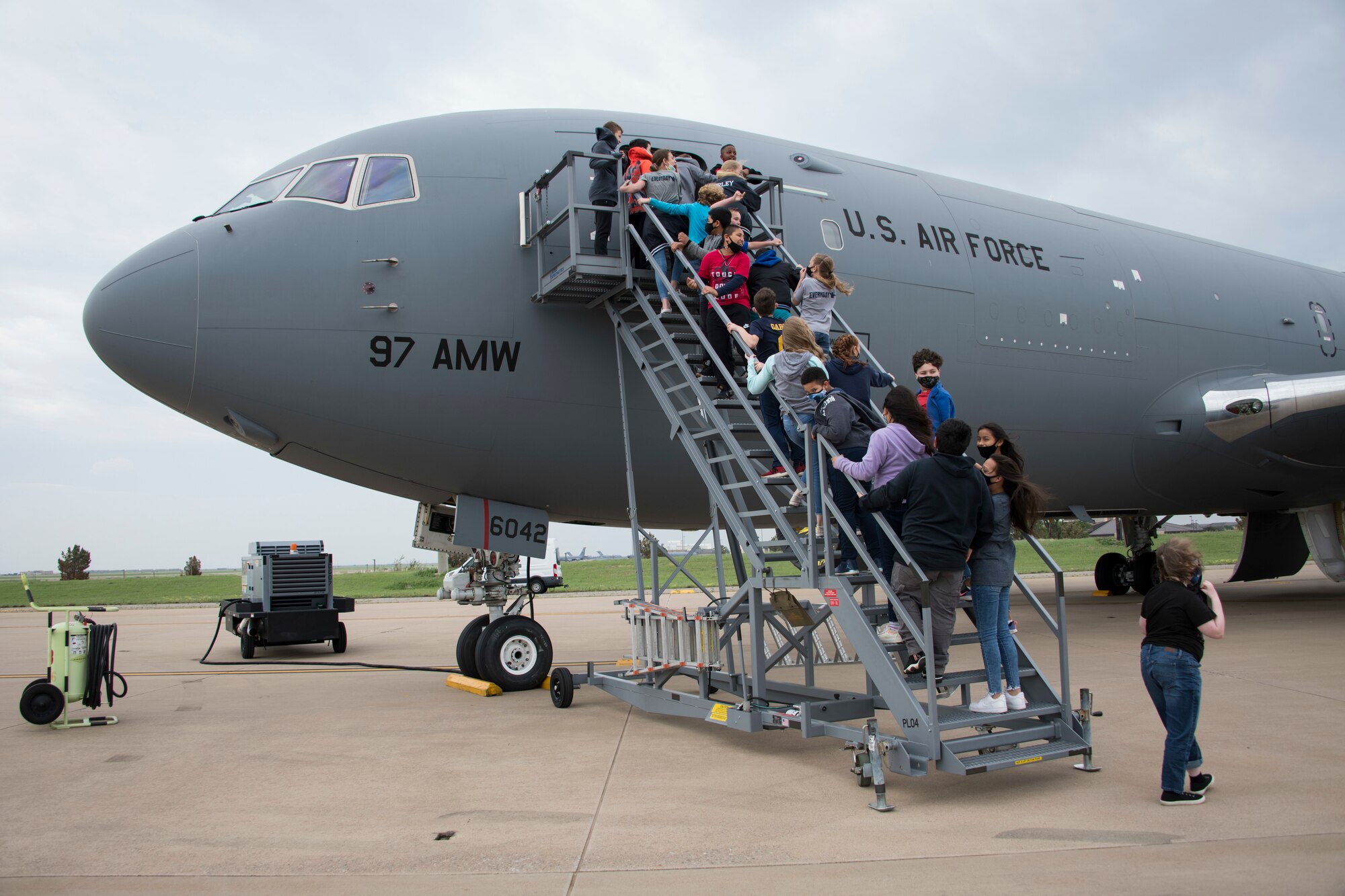 Fifth-grade students from Altus Intermediate School, Navajo Elementary School and Altus Christian Academy wait to view the inside of a KC-46 Pegasus, April 29, 2021, at Altus Air Force Base, Oklahoma. During their visit, students engaged with Airmen, asked questions about aircraft and learned facts like how much weight the planes can carry and how fast they can go. (U.S. Air Force photo by Airman 1st Class Amanda Lovelace)