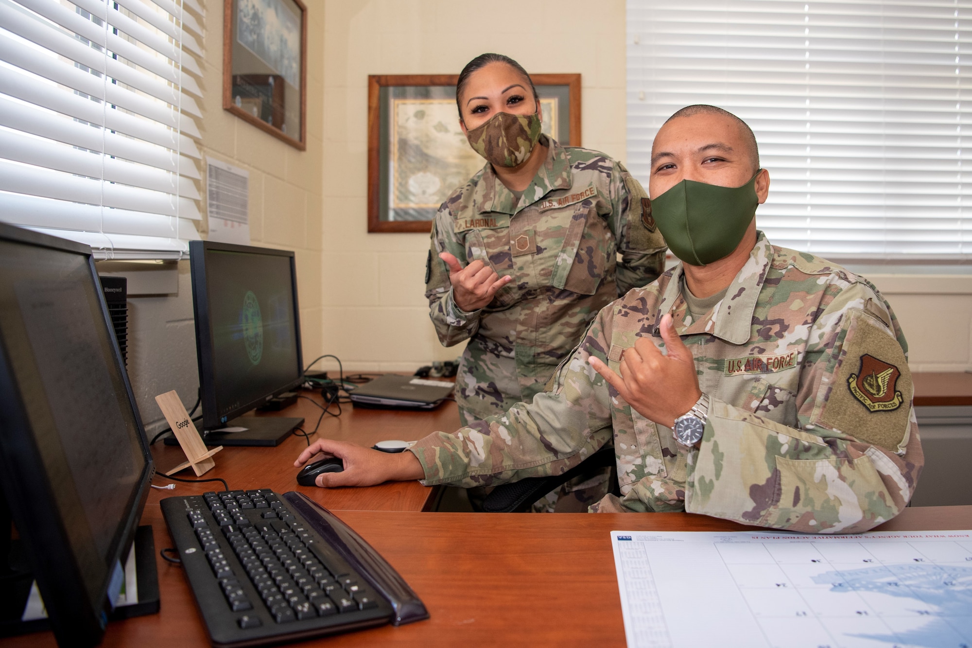 Master Sgt. Jerry Pagaduan, 624th Aeromedical Staging Squadron chief of medical readiness and Master Sgt. Amylyn Laronal, 624th ASTS health services management specialist, display the shaka sign at Joint Base Pearl Harbor-Hickam, Hawaii, April 27, 2021.
