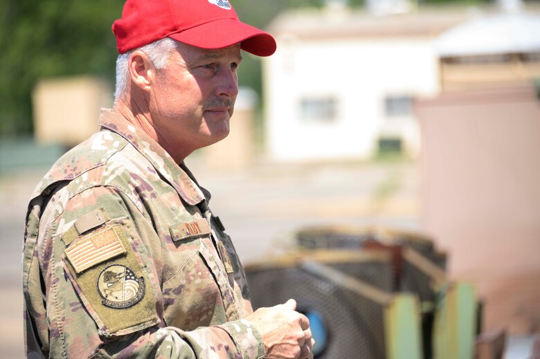 Photo of Airman in red baseball cap speaking.