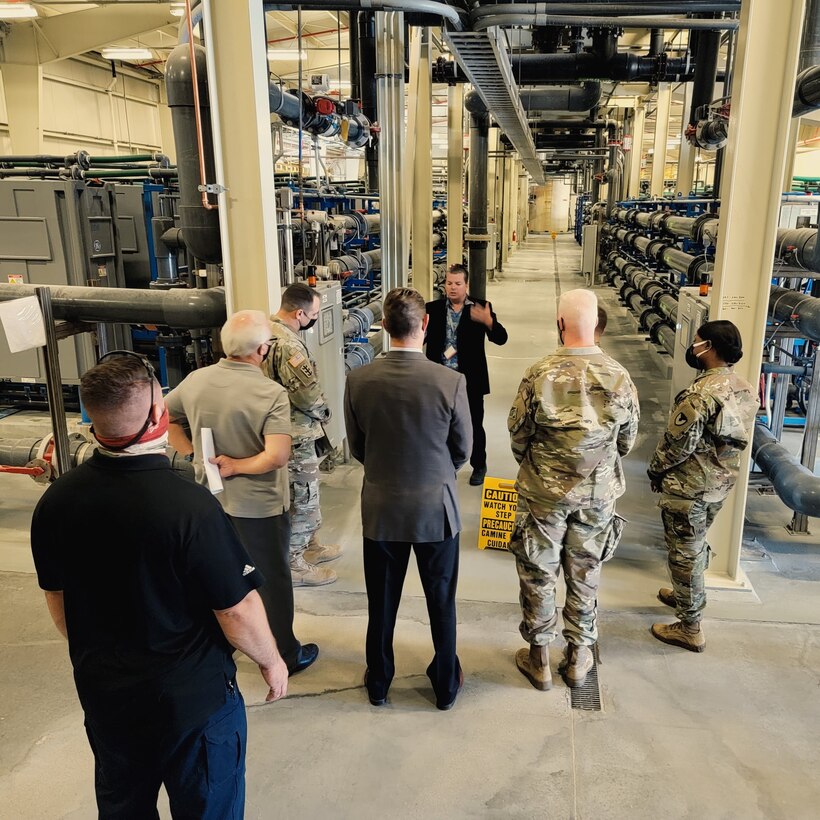 Christopher Woodruff, water resources manager, Fort Irwin Department of Public Works, background center, briefs U.S. Army Corps of Engineers Deputy Commanding General for Military and International Operations Maj. Gen. Jeffrey L. Milhorn and U.S. Army Corps of Engineers South Pacific Division Commander Brig. Gen. Paul Owen about the Fort Irwin Water Works Water Treatment Plant during an April 26 tour of the facility at Fort Irwin, California.