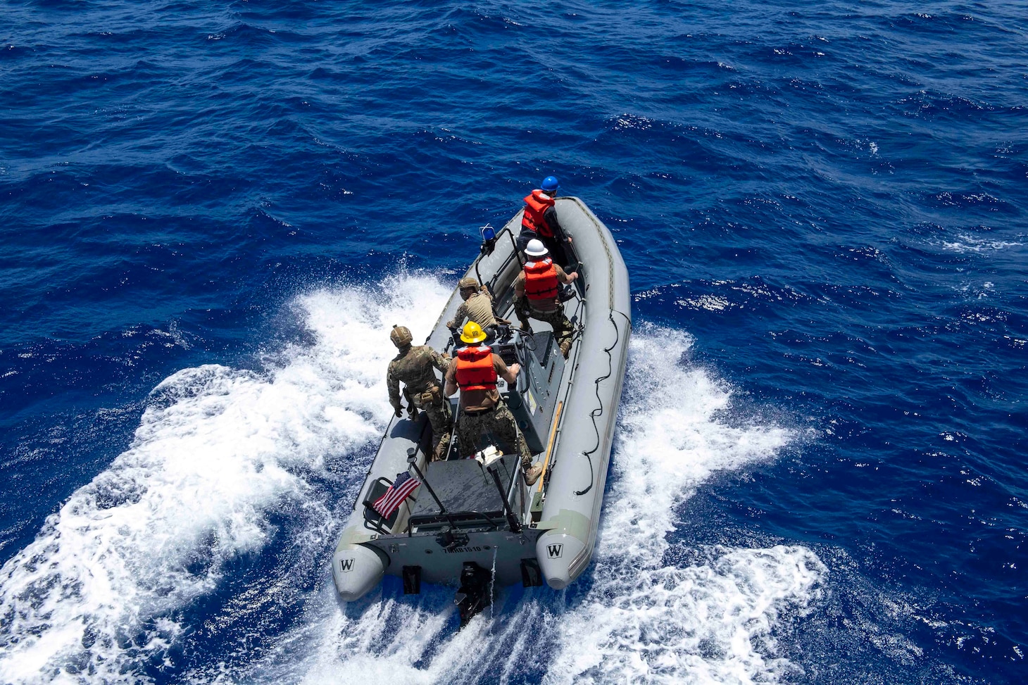 Members of the U.S. Coast Guard  Law Enforcement Detachment 104 and Sailors assigned to Independence-variant littoral combat ship USS Charleston (LCS 18) ride in a rigid-hull inflatable boat.