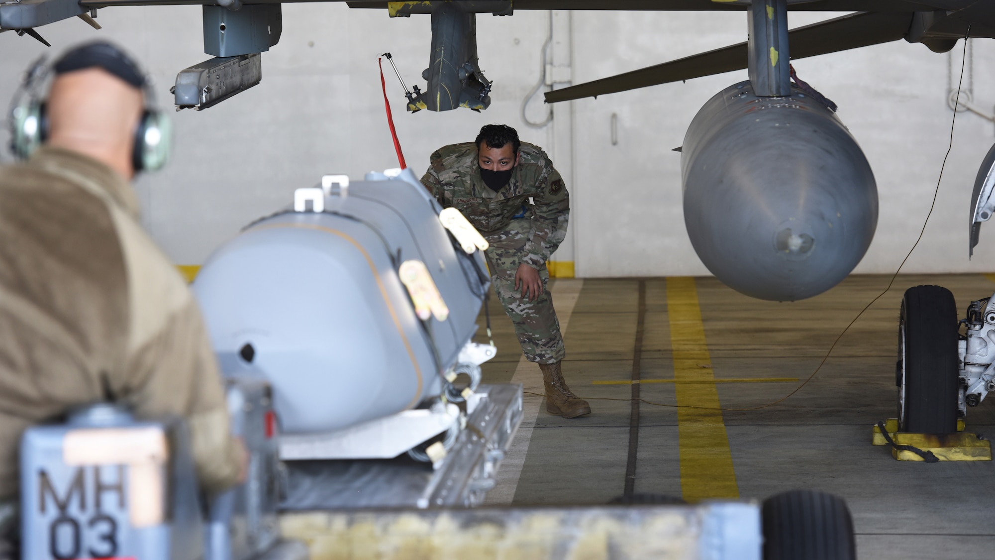 U.S. Air Force Airman First Class Michael Chavarria, 52nd Aircraft Maintenance Squadron weapons load crew member, guides a munition into place during an exercise at Spangdahlem Air Base, Germany, April 27, 2021. The exercise had Airmen successfully load one AGM-158 Joint Air to Surface Standoff Missile and two ADM-160C Miniature Air Launched Decoy missiles onto a U.S. Air Force F-16 Fighting Falcon. (U.S. Air Force photo by Tech. Sgt. Tony Plyler)