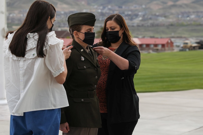 Women pin rank on shoulders of soldier