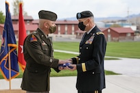 A soldier hands a flag to another soldier