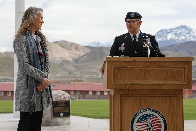 A soldier in uniform speaks with woman