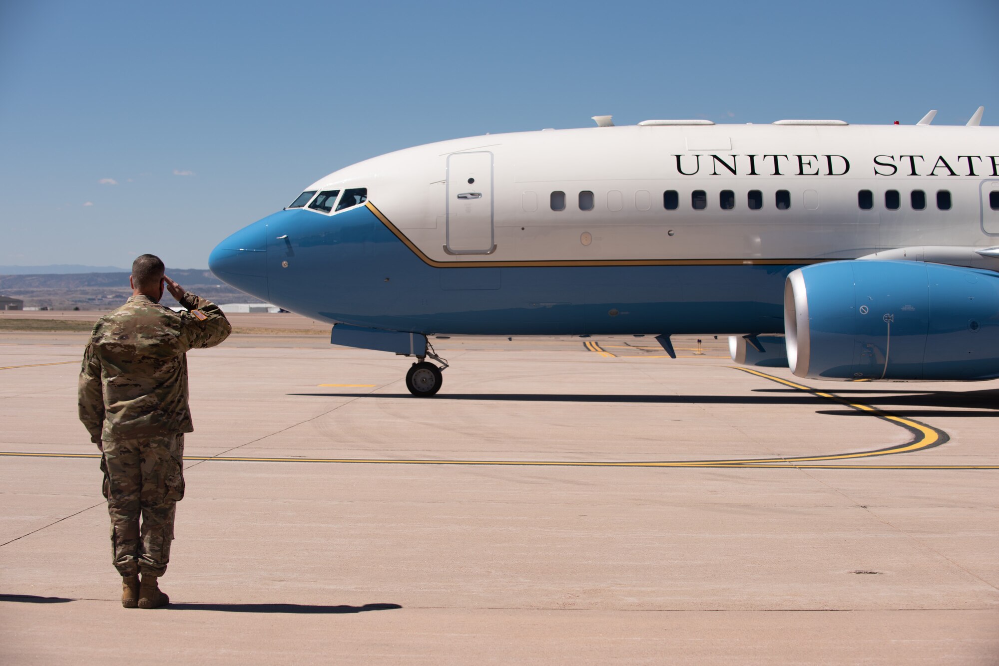 Army. Gen salutes the plane the Secretary of Defense is flying in on.