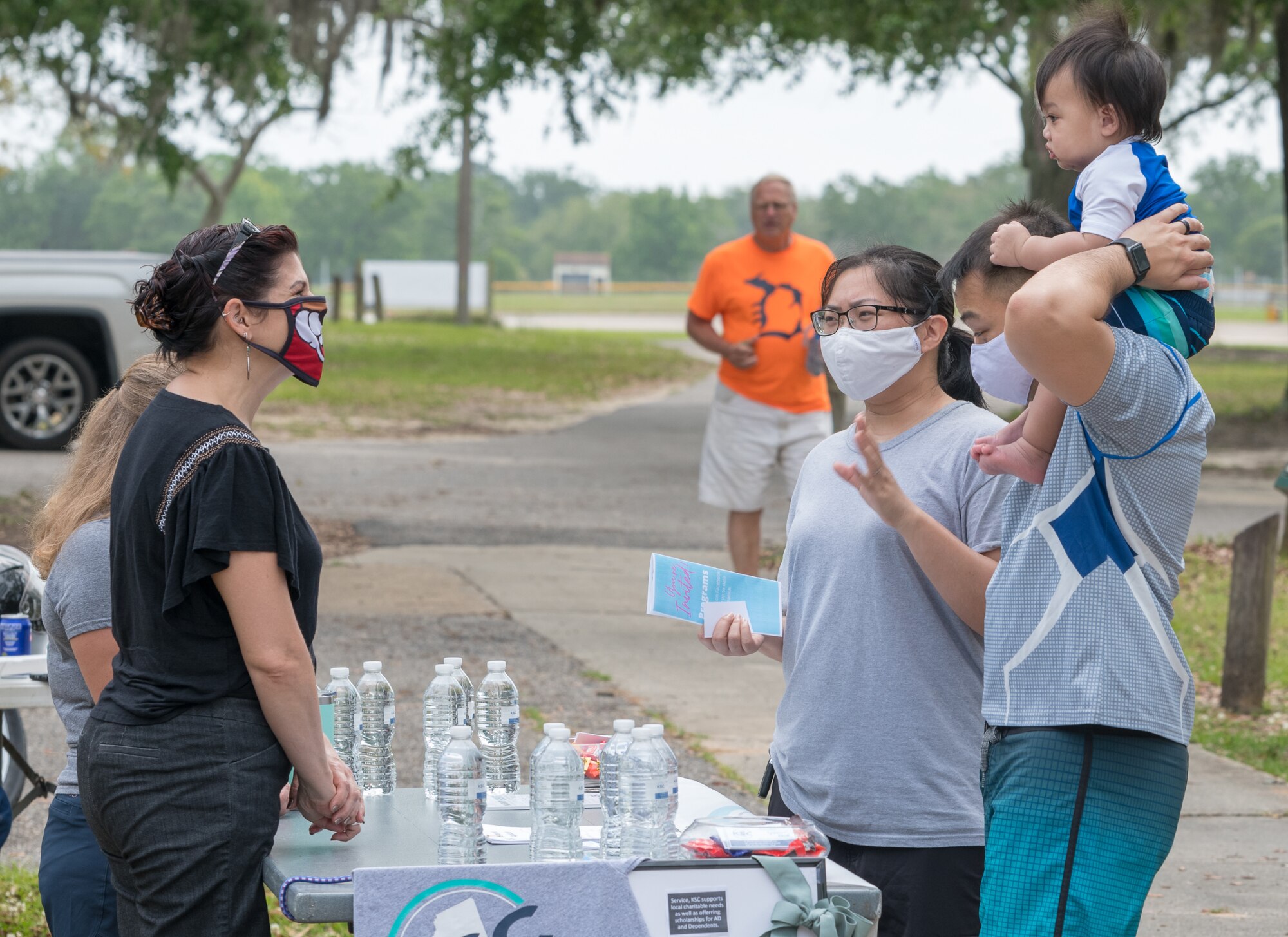 U.S. Air Force Airman 1st Class Andrew Talob, 81st Diagnostic and Therapeutics Squadron lab technician, and family, receive information from the Keesler Spouse’s Club during the Keesler Club Day event at the Marina Park at Keesler Air Force Base, Mississippi, April 29, 2021. The event consisted of a variety of clubs offering information about the benefits they have to offer Keesler personnel and their families. (U.S. Air Force photo by Andre' Askew)