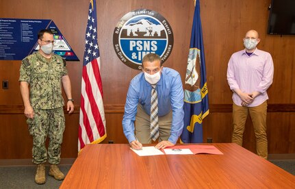 Capt. Kenneth Shepard, Code 900, Production Resources Department officer, Mark Employees recognized for their communication innovation Johnson, Code 106, Environmental, Safety and Health director, and Cody Matheson, Code 106, Environmental, Safety and Health deputy director sign a document May 29, 2020, establishing the PSNS & IMF Safety Management System. (PSNS & IMF photo by Wendy Hallmark)