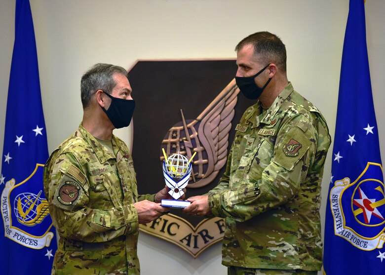U.S. Air Force Gen. Ken Wilsbach, Pacific Air Forces commander, presents Col. Daniel Dobbels, 15th Wing commander with the PACAF Innovation Awards’ third-place trophy at Joint Base Pearl Harbor-Hickam, Hawaii, April 22, 2021. Airmen from the 15th Wing presented the idea of using virtual reality headsets to accomplish various training tasks throughout the year in a controllable environment. (U.S. Air Force photo by Tech. Sgt. Jimmie D. Pike)
