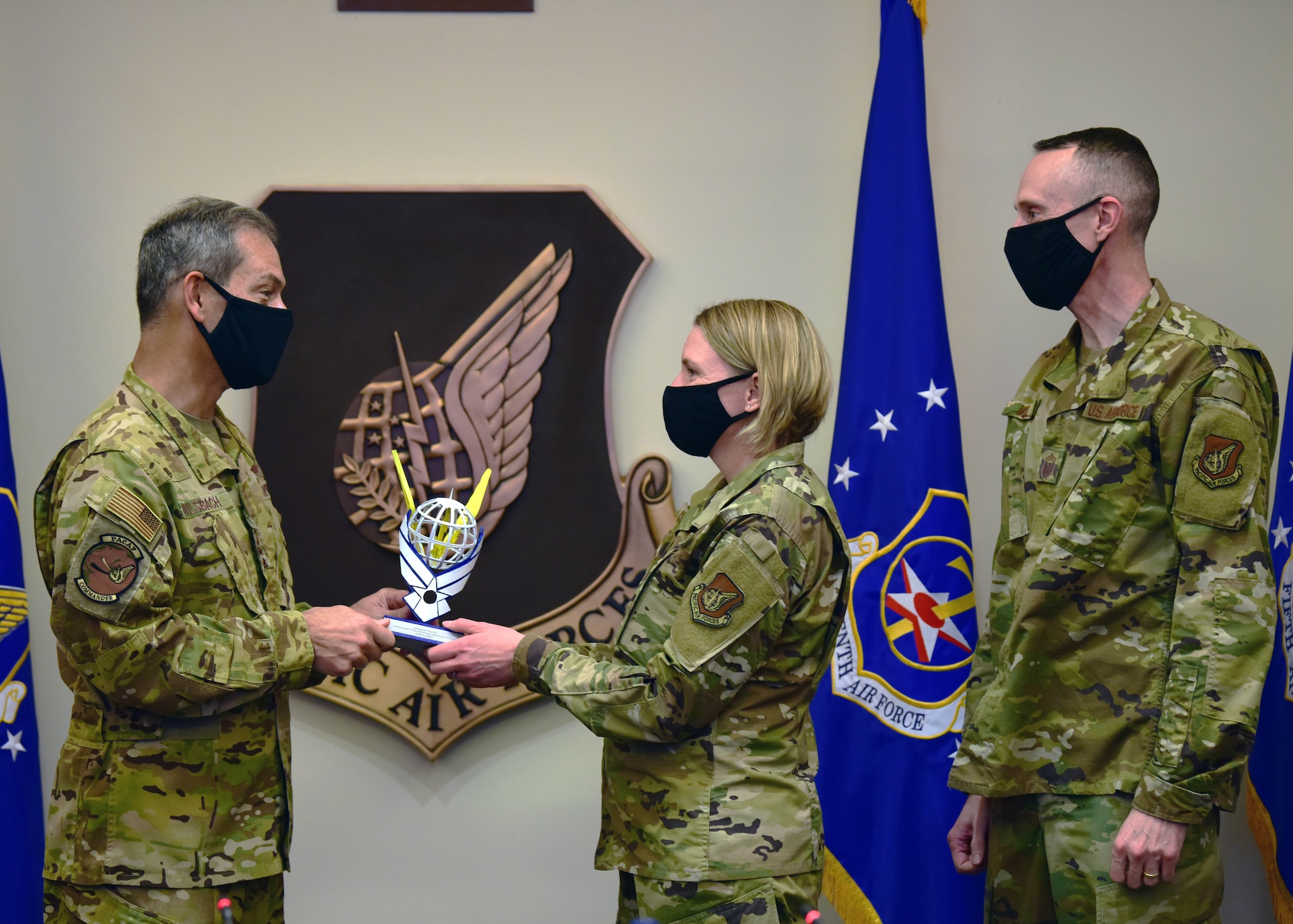 U.S. Air Force Gen. Ken Wilsbach, Pacific Air Forces commander, presents Col. Kirsten Aguilar, Joint Base Elmendorf-Richardson and 673rd Air Base Wing commander, and Chief Master Sgt. Lee Mills, JBER and 673rd ABW command chief, with the PACAF Innovation Awards’ second-place trophy at Joint Base Pearl Harbor-Hickam, Hawaii, April 22, 2021. Second place earned full funding for 673rd ABW’s idea to consolidate deployment logistics by created a one-stop shop for unit deployment managers to order deployers’ gear. (U.S. Air Force photo by Tech. Sgt. Jimmie D. Pike)