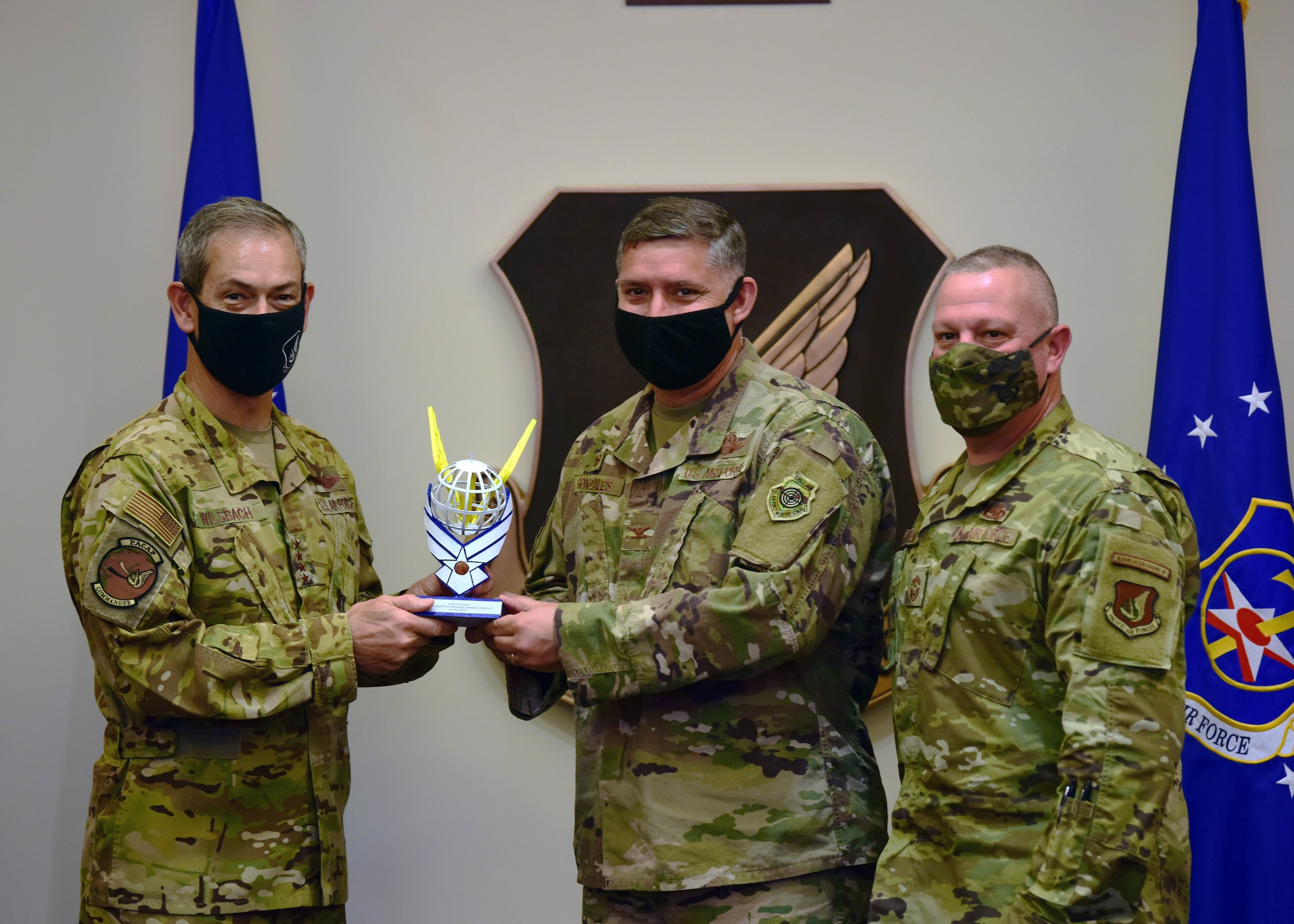 U.S. Air Force Gen. Ken Wilsbach, Pacific Air Forces commander, presents Col. John Gonzales, 51st Fighter Wing commander, and Chief Master Sgt. Justin Apticar, 51st FW command chief, with the PACAF Innovation Awards’ first-place trophy at Joint Base Pearl Harbor-Hickam, Hawaii, April 22, 2021. The 51st FW garnered first-pace and full funding for their idea concerning improved power generators for aircraft which would reduce hazardous fumes within aircraft shelters and help generate sorties. (U.S. Air Force photo by Tech. Sgt. Jimmie D. Pike)