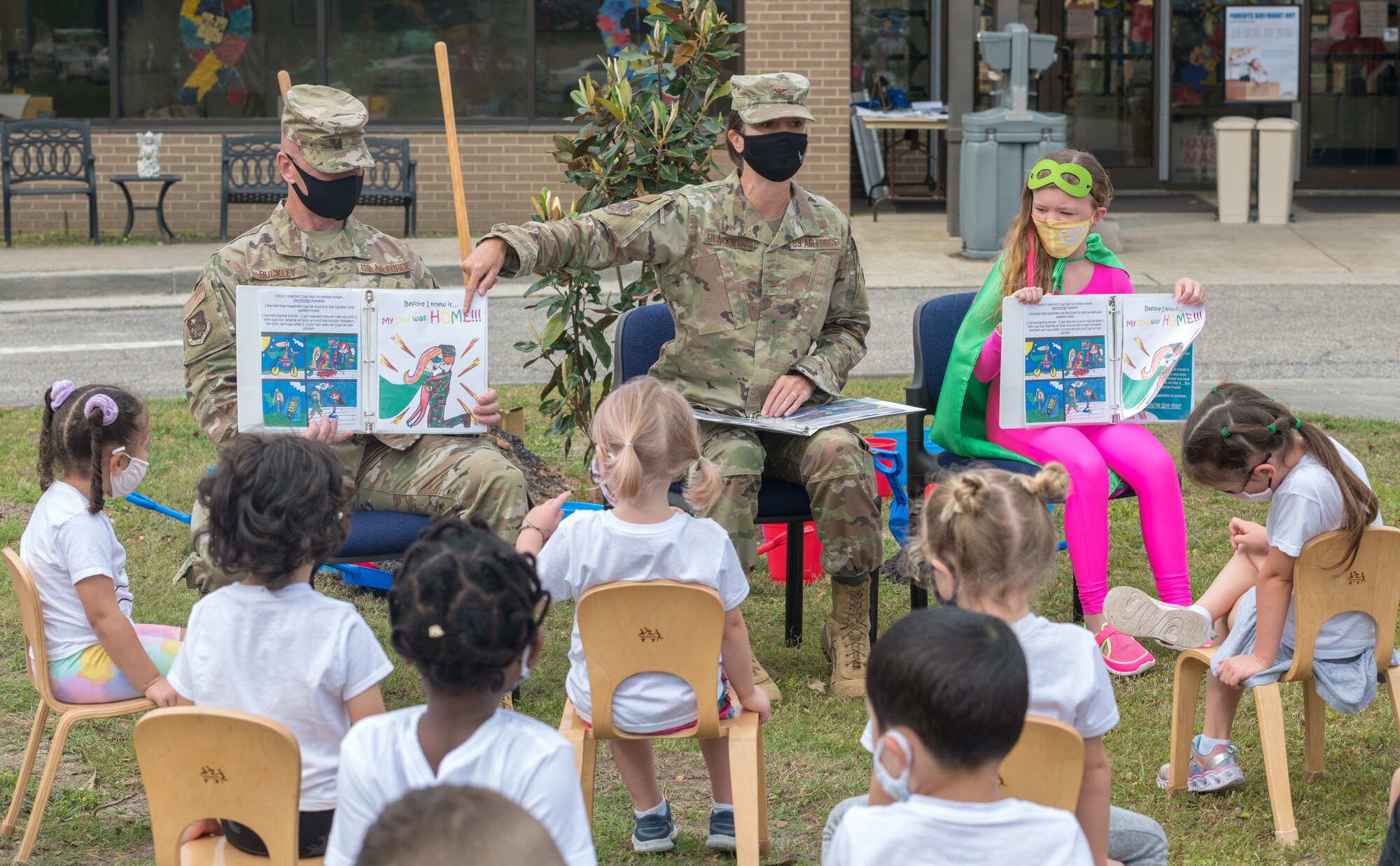 U.S. Air Force Col. Heather Blackwell, 81st Training Wing commander, and Chief Master Sgt. Jason Buckley, 81st Training Group superintendent, reads the book, Finding Happiness In Sadness, written by Meddie Tuckey, daughter of Tech. Sgt. Gregory Tuckey, 338th Training Squadron instructor supervisor, to a preschool class at the child development center during the Arbor Day Celebration at Keesler Air Force Base, Mississippi, April 30, 2021. A tree planting ceremony also took place at the event. (U.S. Air Force photo by Andre' Askew)