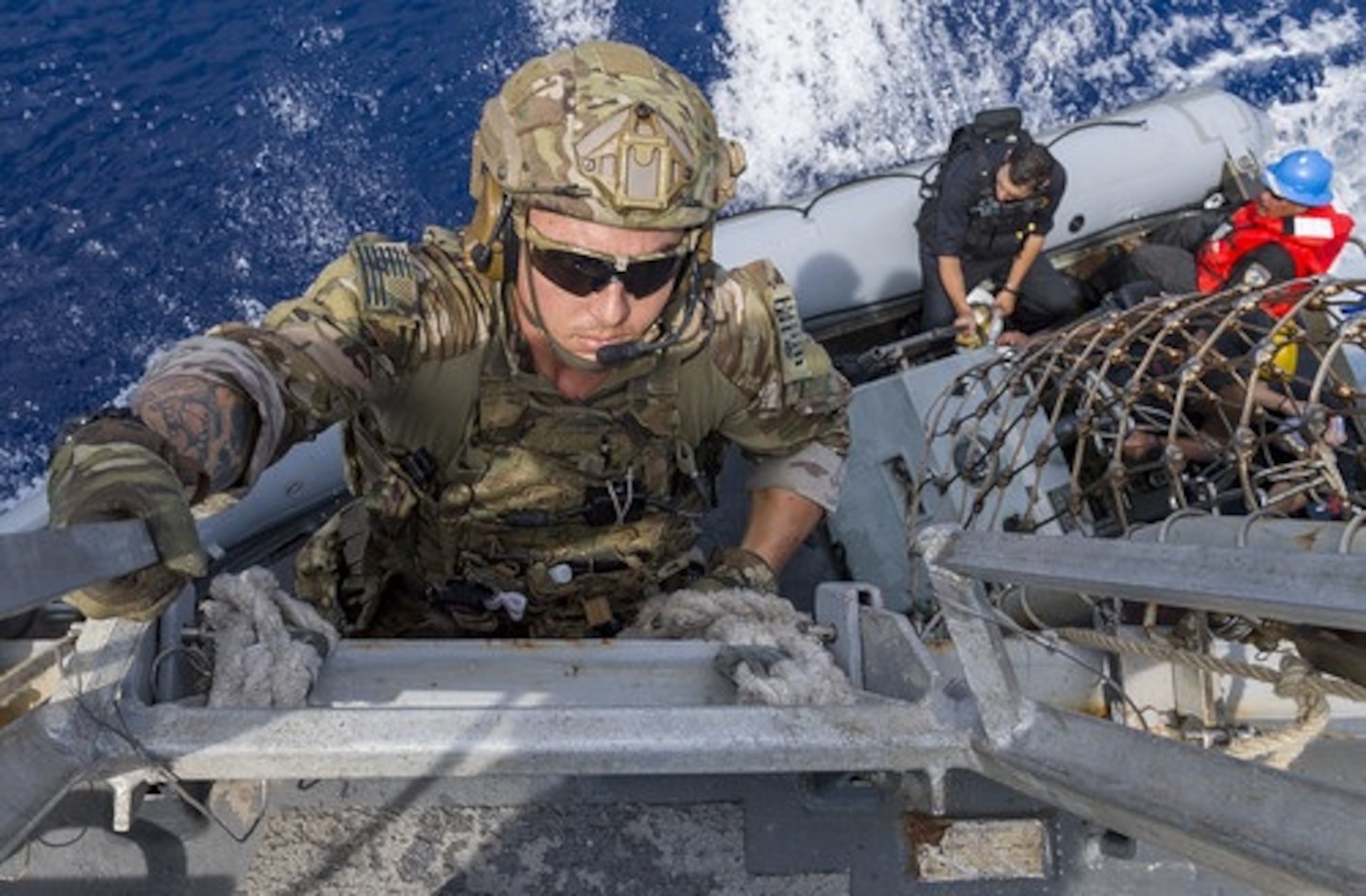 In this file photo, a member a member of a U.S. Coast Guard law enforcement detachment climbs down to a rigid-hull inflatable boat during an OMSI boarding mission in 2018. (U.S. Navy/MC3 Jasen Morenogarcia)