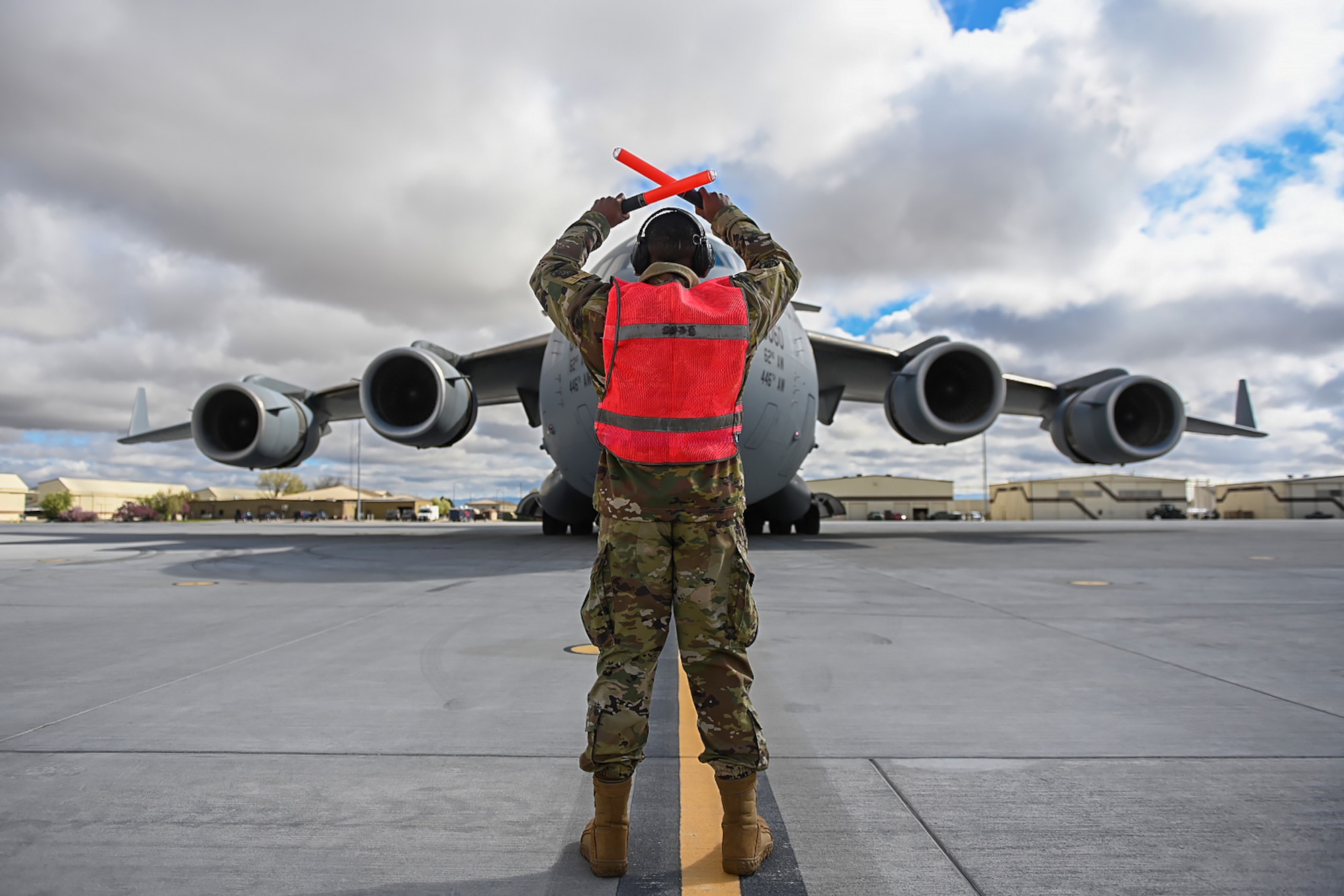 Senior Airman Antoine Barnes, 821st Contingency Response Squadron fire team member, marshals a C-17 Globemaster III from Joint Base Lewis-McChord, Washington, April 27, 2021, on the flight line at Mountain Home AFB, Idaho. Barnes participated in exercise Rainier War, testing his abilities to employ air combat capabilities during a time of potentially imminent foreign aggression. (U.S. Air Force photo by Staff Sgt. Christian Conrad)