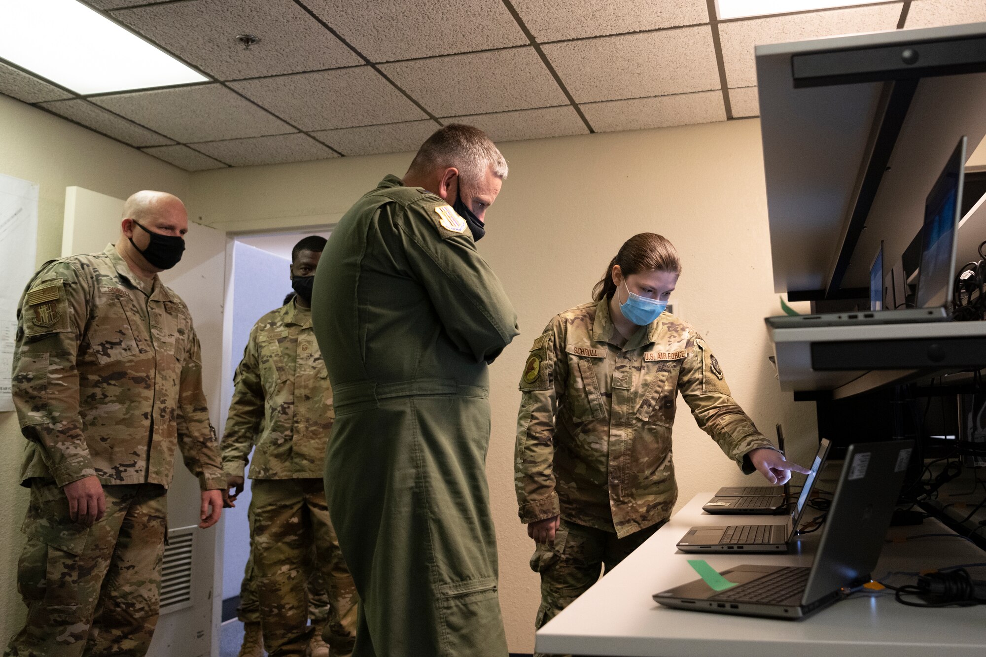 Airman 1st Class Alyssa Schroll, right, 60th Communications Squadron client system technician, demonstrates the client system mission to Col. Corey Simmons, 60th Air Mobility Wing commander, center, and Chief Master Sgt. Robert Schultz, 60th AMW command chief, far left, during Leadership Rounds April 30, 2021, at Travis Air Force Base, California. The Leadership Rounds program provides 60th AMW leadership an opportunity to interact with Airmen and receive a detailed view of each mission performed at Travis AFB. (U.S. Air Force photo by Airman 1st Class Alexander Merchak)