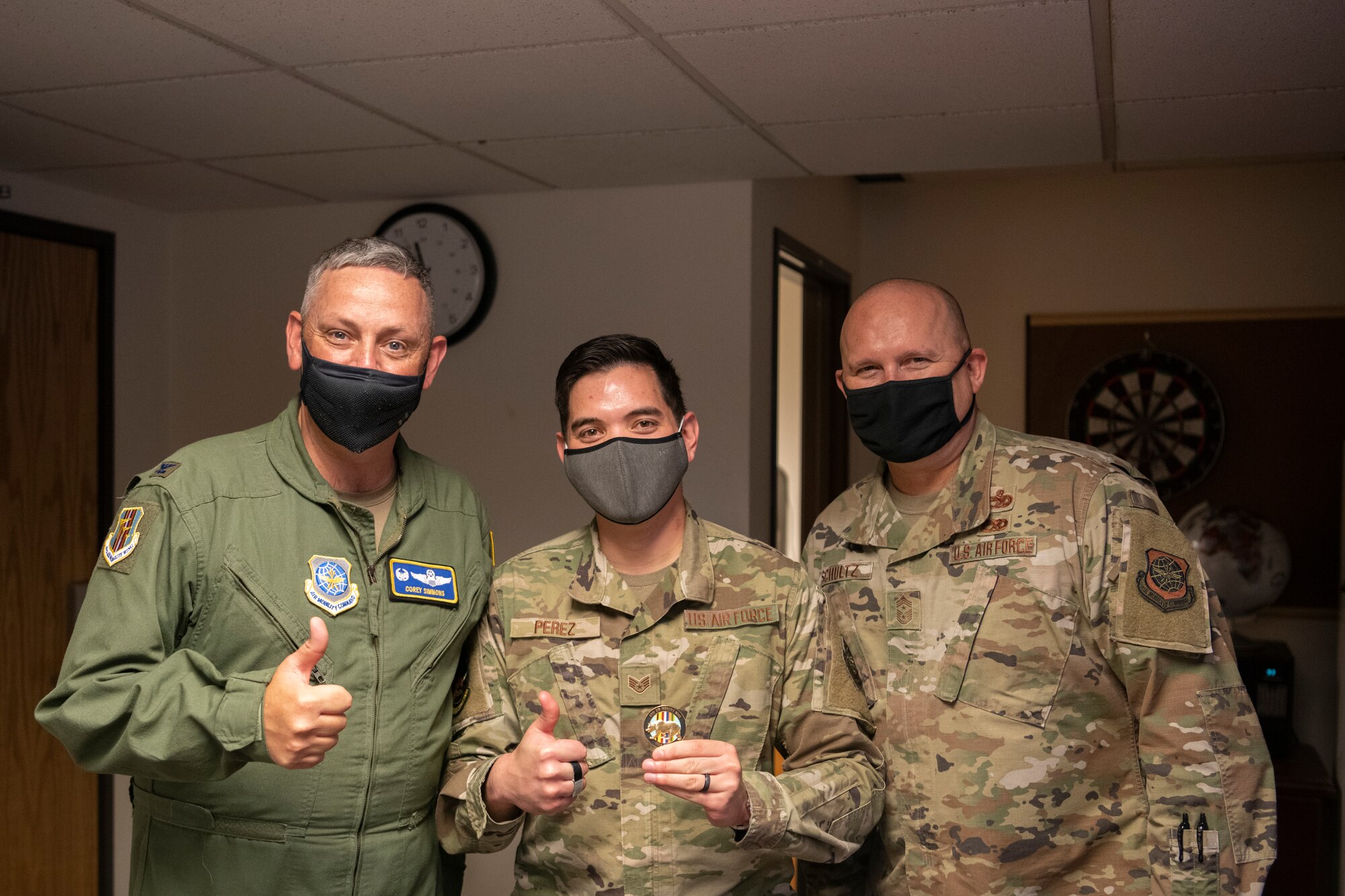 U.S. Air Force Col. Corey Simmons, left, 60th Air Mobility Wing commander, and Chief Master Sgt. Robert Schultz, right, 60th AMW command chief, recognize Staff Sgt. Bernardino Perez, 60th Communications Squadron cyber security technician, as a high-performance team member during Leadership Rounds April 30, 2021, at Travis Air Force Base, California. The Leadership Rounds program provides 60th AMW leadership an opportunity to interact with Airmen and receive a detailed view of each mission performed at Travis AFB. (U.S. Air Force photo by Airman 1st Class Alexander Merchak)