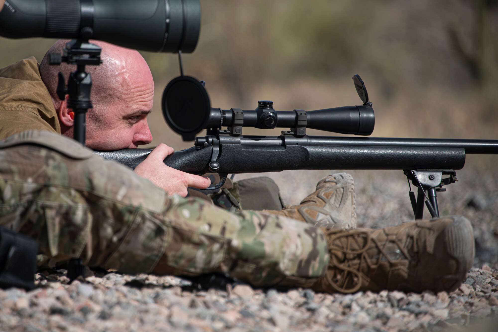 A photo of an Airman aiming a weapon