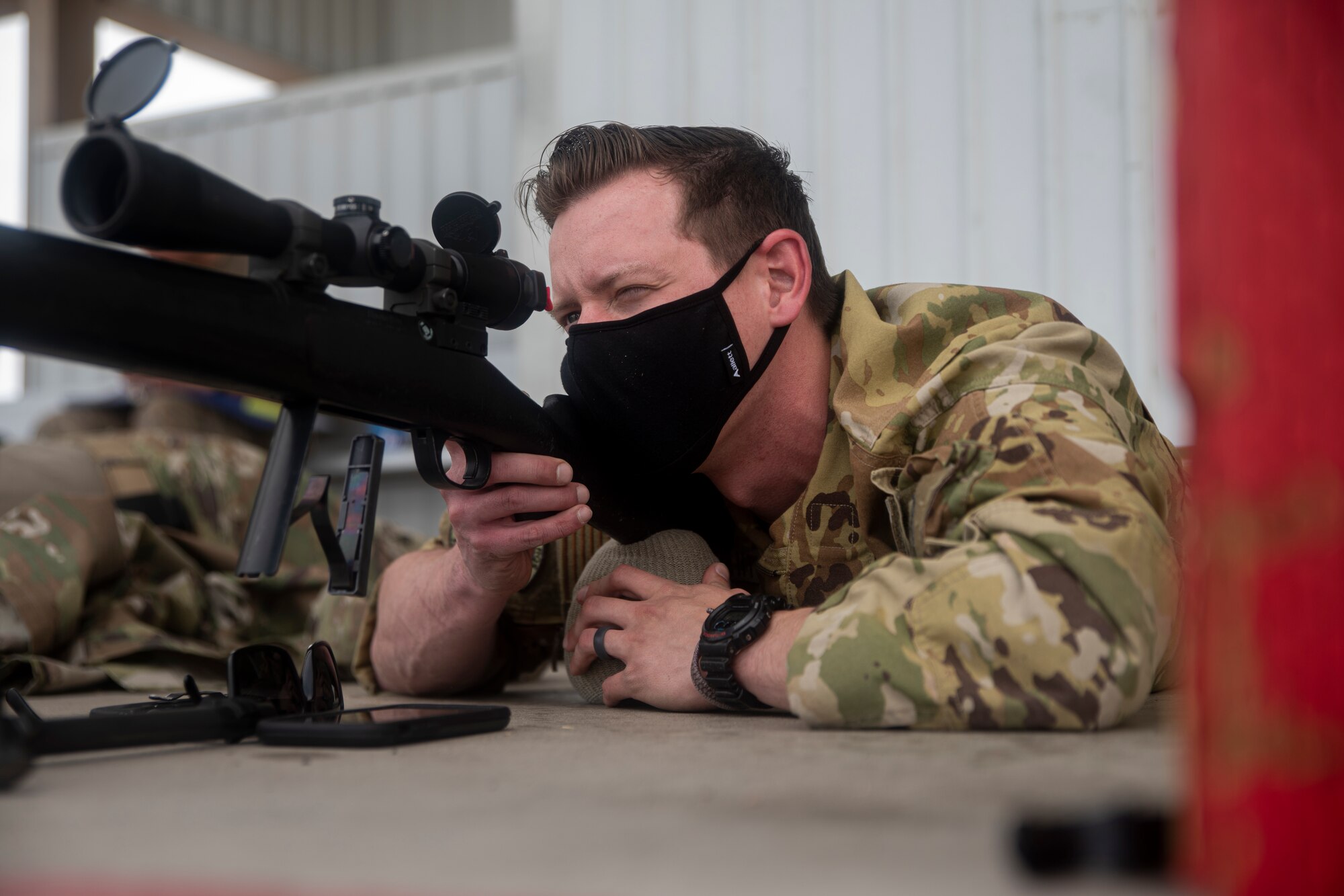A photo of an Airman aiming a weapon