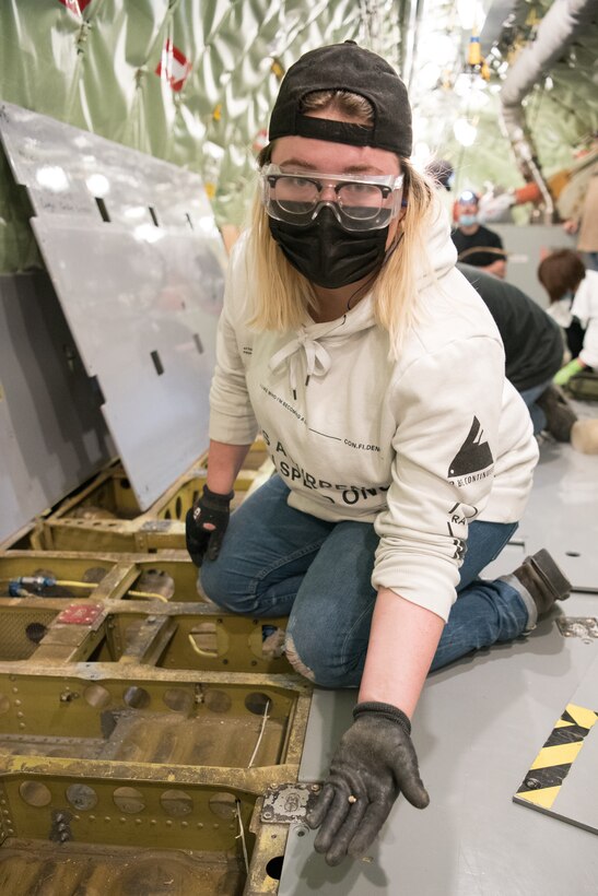 Woman holding a rivet inside an aircraft