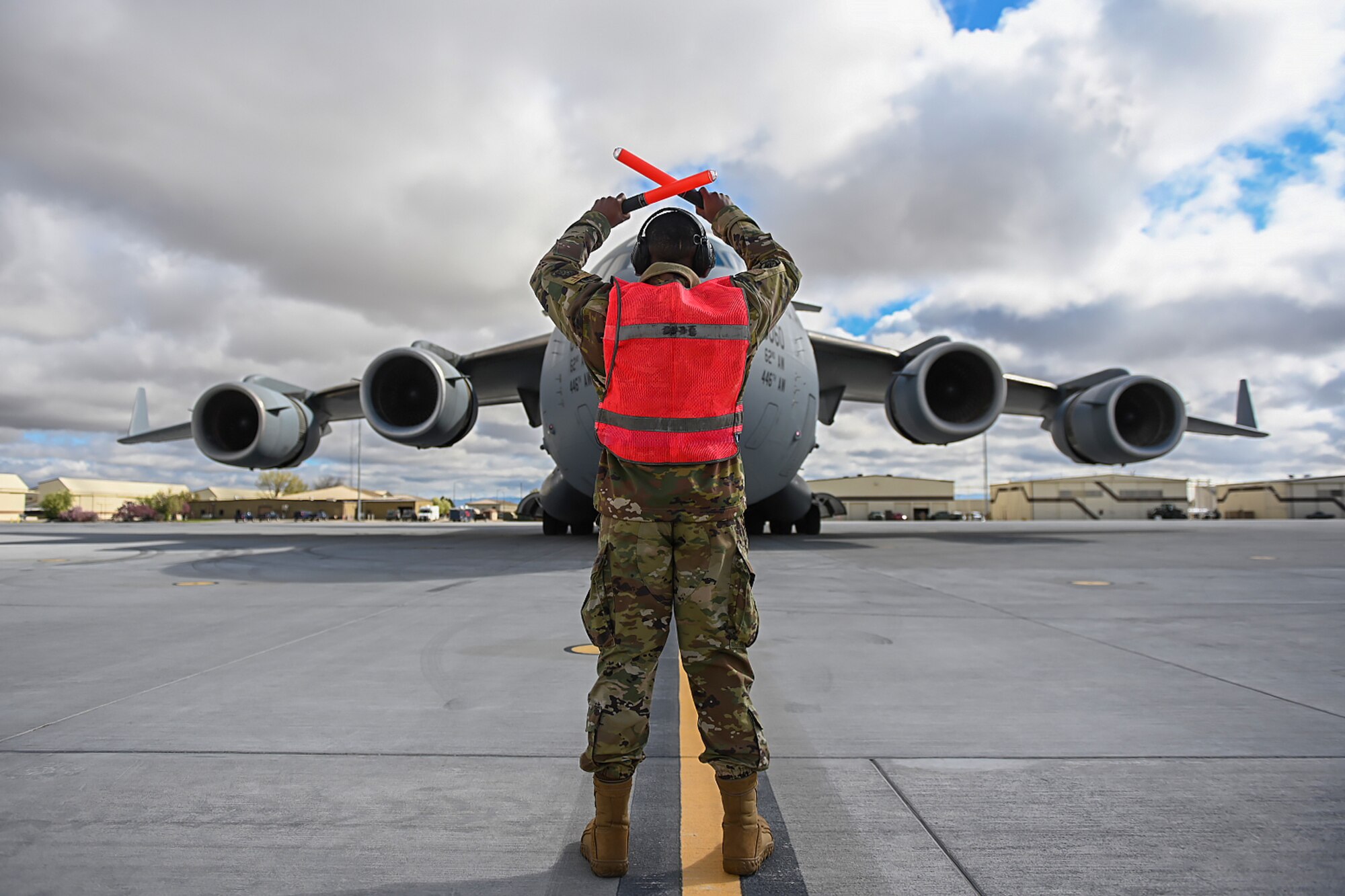 Senior Airman Antoine Barnes, 821st Contingency Response Squadron fire team member, marshals a C-17 Globemaster III from Joint Base Lewis-McChord, Washington, April 27, 2021, on the flight line at Mountain Home AFB, Idaho. Barnes participated in exercise Rainier War, testing his abilities to employ air combat capabilities during a time of potentially imminent foreign aggression. (U.S. Air Force photo by Staff Sgt. Christian Conrad)