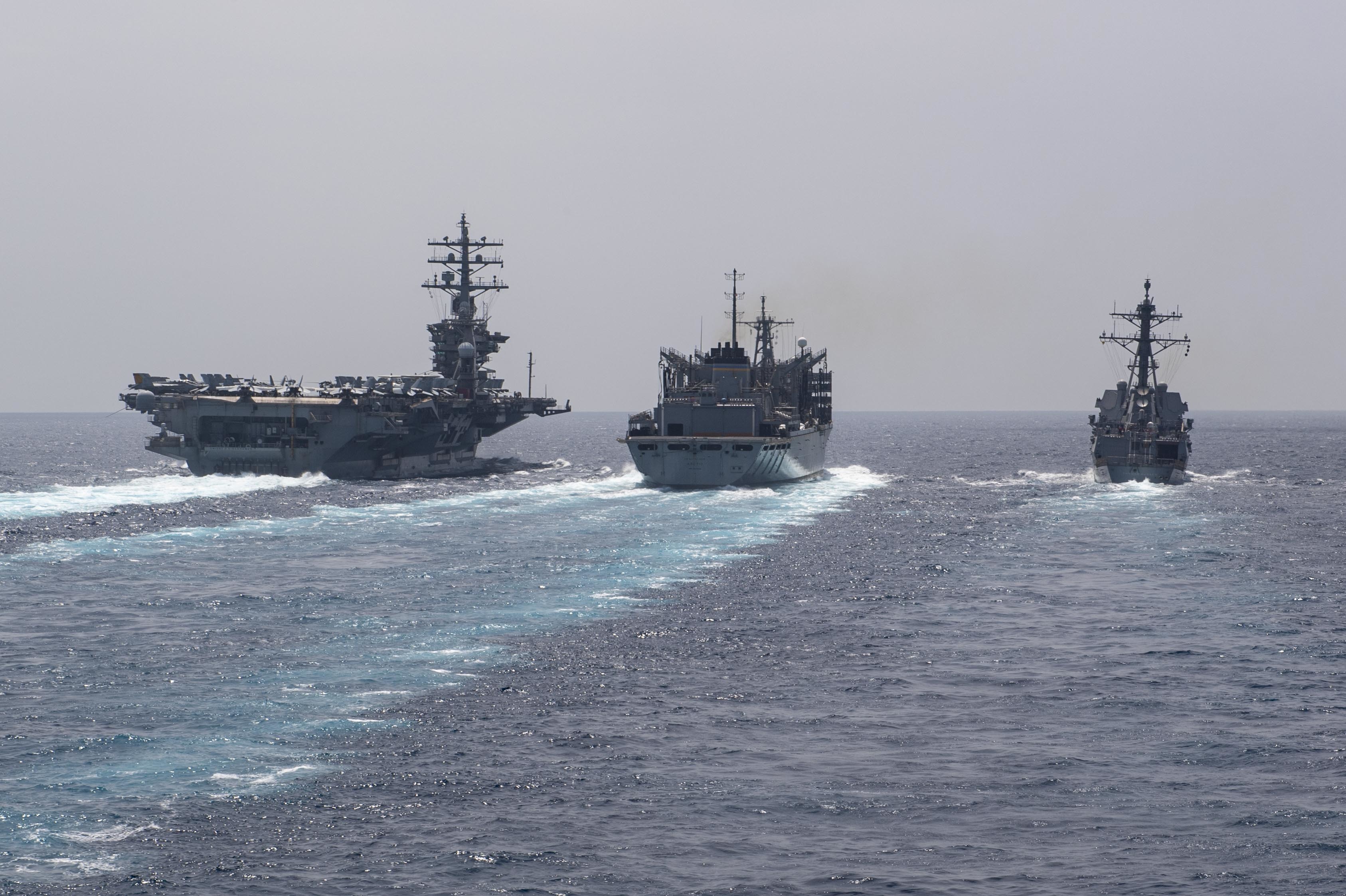 USS Dwight D. Eisenhower (CVN 69), left, USNS Arctic (T-AOE-8), center, and USS Thomas Hudner (DDG 116) conduct a replenishment-at-sea in the Arabian Sea.