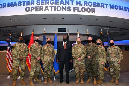 Secretary of Defense and other military personnel pose for a photo.