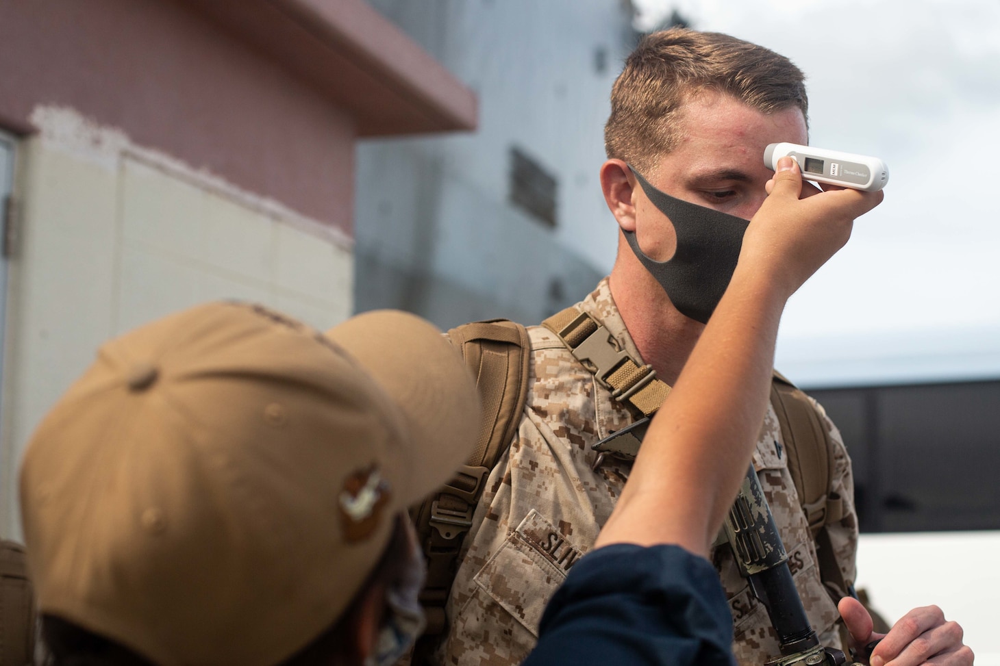 200828-M-MR595-0467 WHITE BEACH NAVAL BASE, OKINAWA (Aug. 28, 2020) A U.S. Marine with Battalion Landing Team 2/4, 31st Marine Expeditionary Unit has his temperature checked by Seaman Litzy Campos, a native of Phoenix, Arizona, embarked with Whidbey Island-class dock landing ship USS Germantown (LSD 42). Germantown, part of the America Amphibious Ready Group (ARG), 31st MEU team, is operating in the U.S. 7th Fleet area of operation to enhance interoperability with allies and partners and serve as a ready response force to defend peace and stability in the Indo-Pacific region. The America ARG, 31st MEU team remains the premier crisis response force in the region despite the unique challenges caused by the COVID-19 pandemic. (U.S. Marine Corps photo by Sgt. Danny Gonzalez)