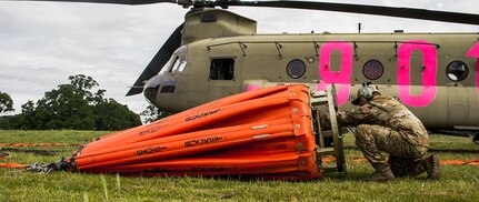 A U.S. Army Soldier from the 3-140th Aviation Regiment, California National Guard, performs a final check on the water bucket of a U.S. Army CH-47 Chinook helicopter before participating in annual joint aerial fire fighting training near Ione, California, April 24, 2021.
