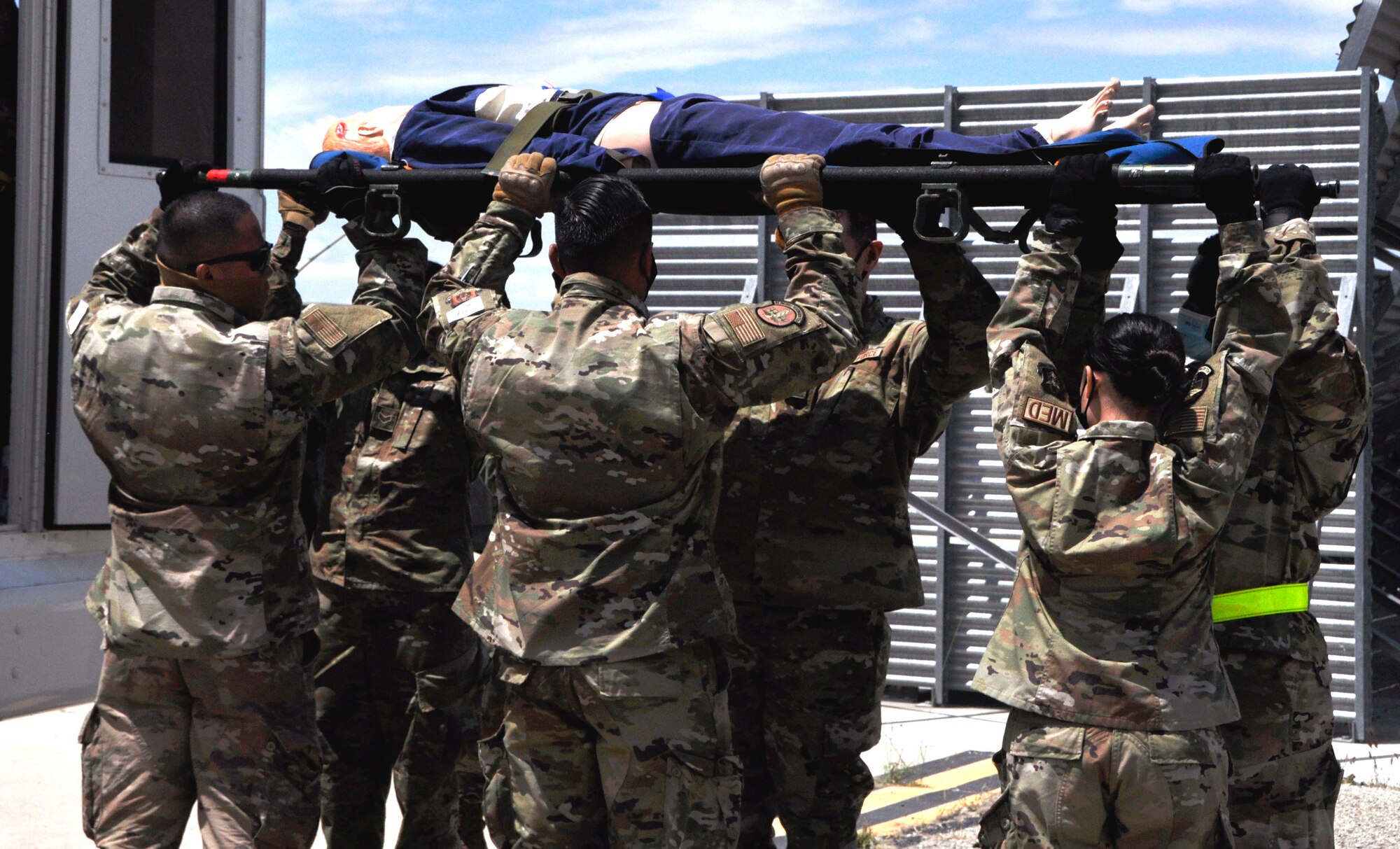 Image of Airmen lifting a stretcher.