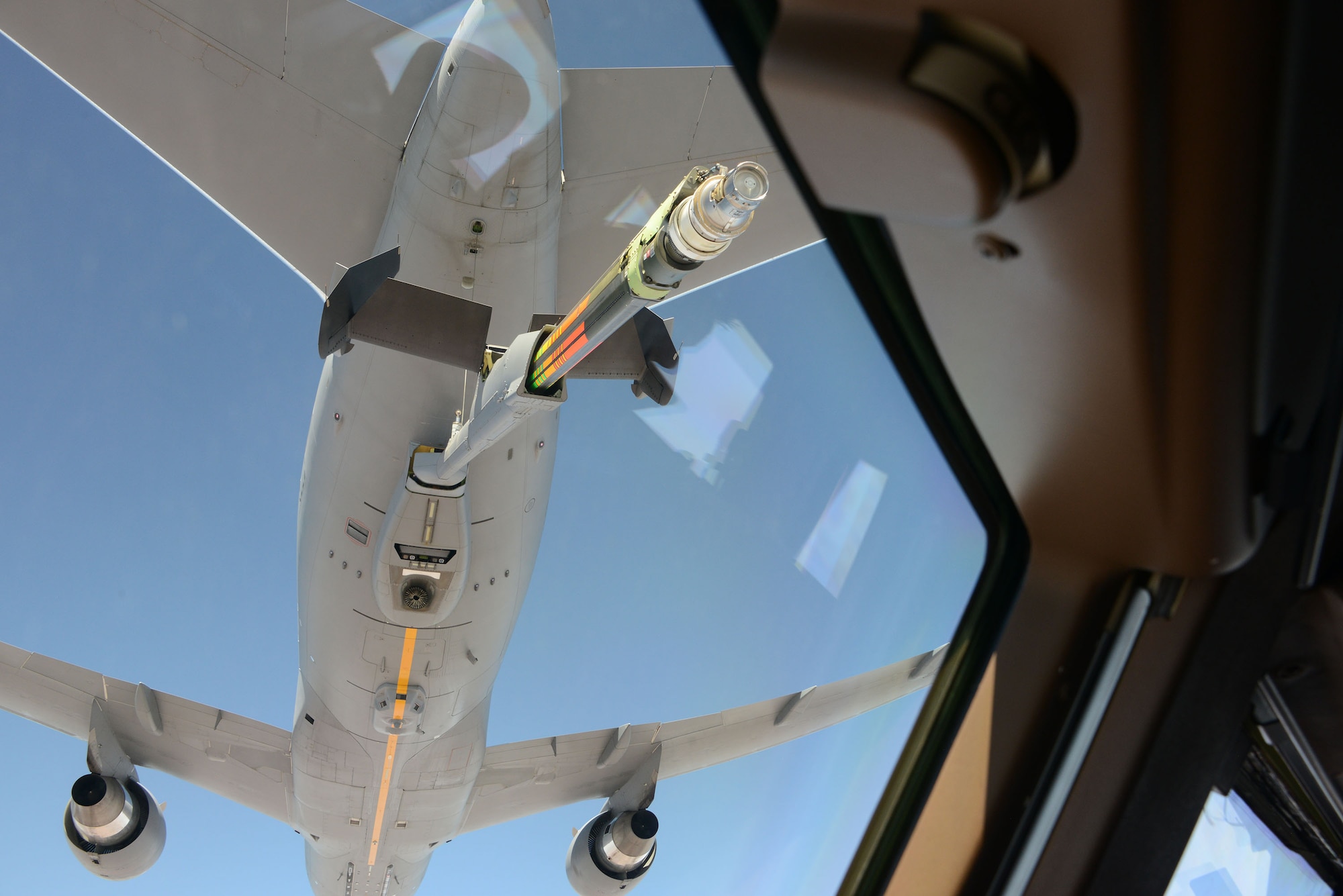 A KC-46 Pegasus approaches another KC-46 as the boom is about to attach for refueling during a training mission.