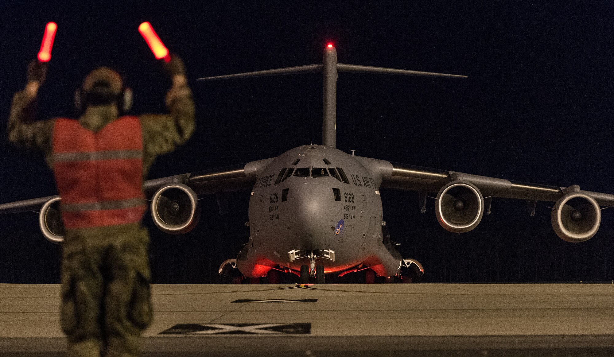 Airman 1st Class Bain Adair, 736th Aircraft Maintenance Squadron integrated avionics journeyman, marshals a C-17 Globemaster III at Dover Air Force Base, Delaware, April 23, 2021. The C-17 can perform tactical airlift missions, as well as aeromedical evacuations to and from locations anywhere in the world. (U.S. Air Force photo by Roland Balik)