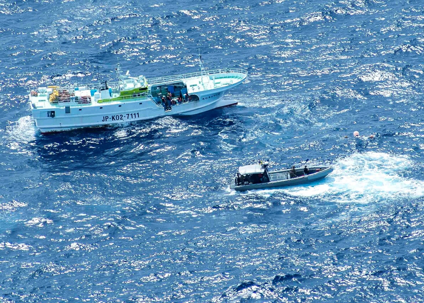 U.S. Coast Guardsmen approach a foreign vessel during an Oceania Maritime Security Initiative (OMSI) boarding.
