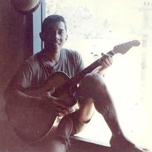 Photo of Lance Cpl. Miguel Keith deployed in Vietnam. Marine is posing with a guitar.
