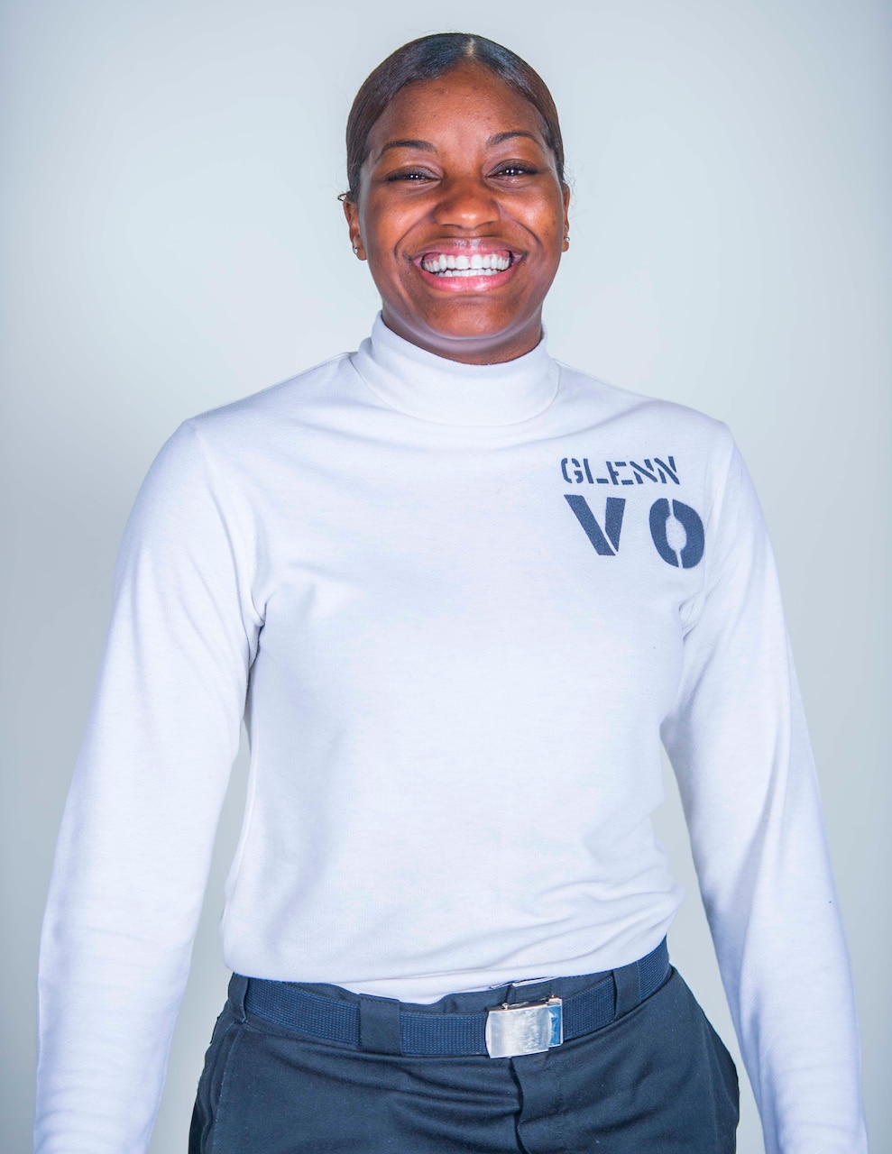 Photo of a Sailor smiling with hair done within grooming standards.