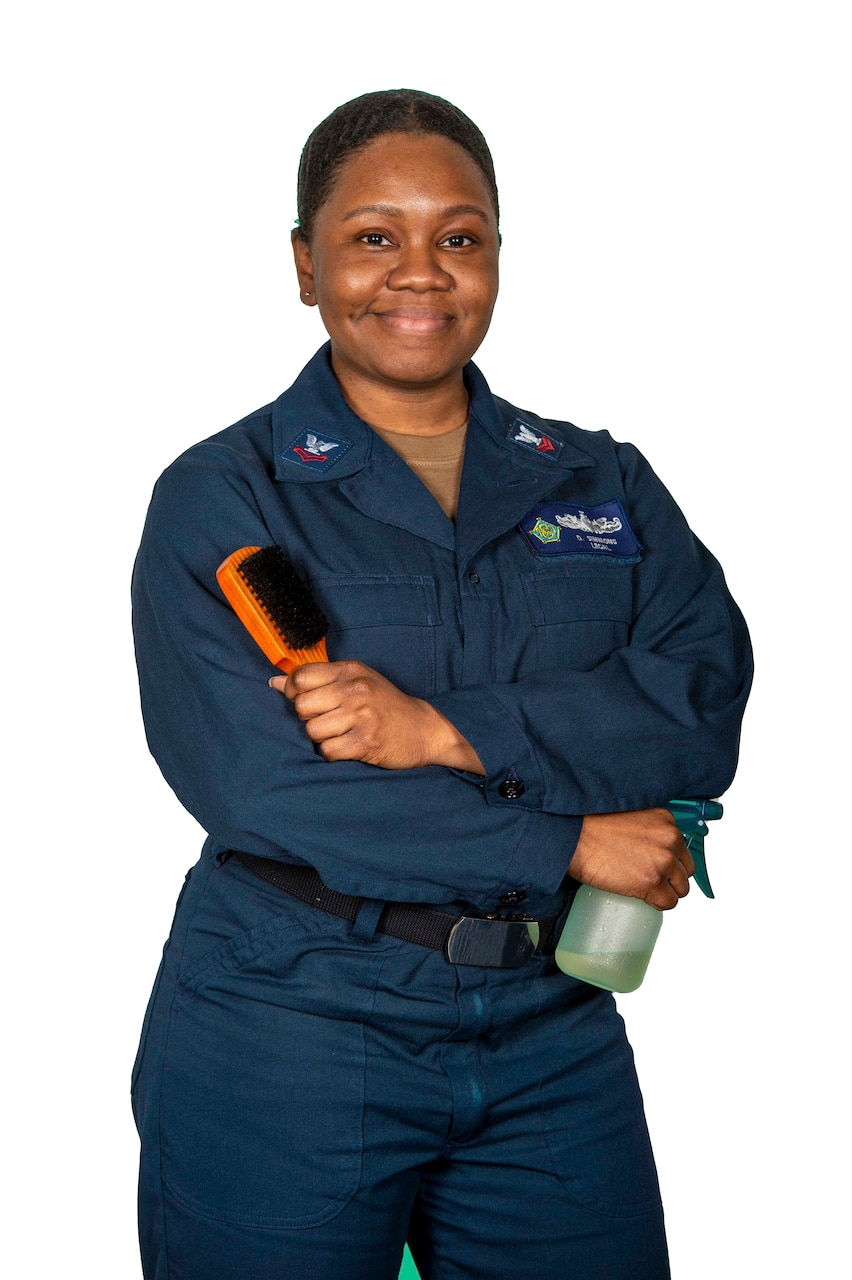 Photo of a Sailor posing with hair brush and spray bottle.