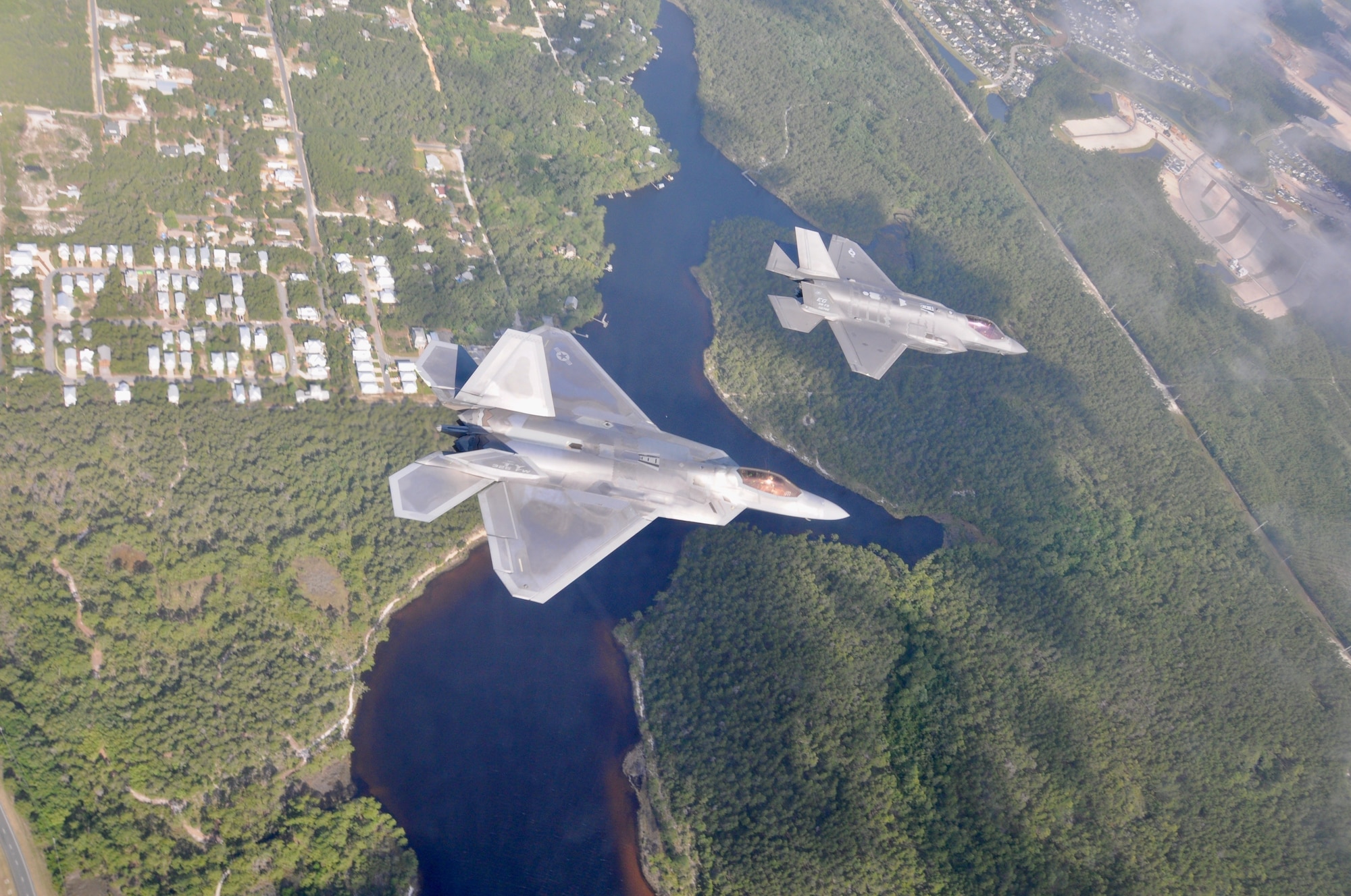 A F-22 Raptor from the 325th Fighter Wing flies alongside a F-35 Lightning II from the 33rd Fighter Wing over the Emerald Coast. The fifth generation fighter jets flew together in a rare dissimilar formation to salute healthcare workers, first responders and other essential employees May 15, 2020. (U.S. Air Force photo by 1st Lt Savanah Bray)