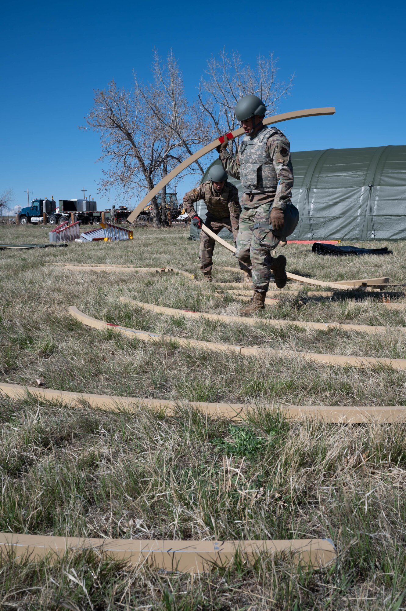 Members of the 819th RED HORSE Squadron lay out the interior structure of a sleeping tent May 3, 2021, at Malmstrom Air Force Base, Mont.