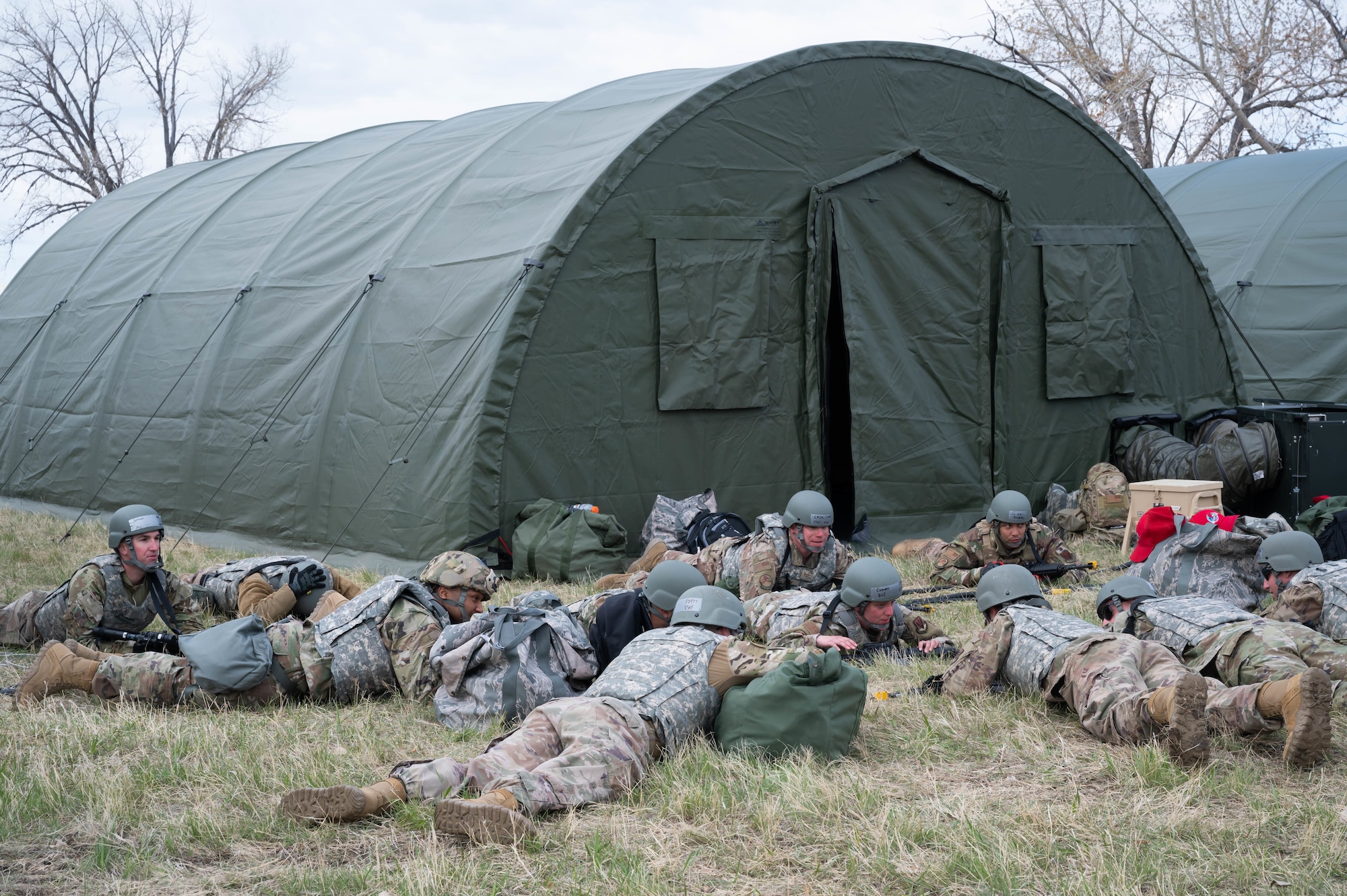 Members of the 819th RED HORSE Squadron lie low to the ground during a simulated attack scenario May 3, 2021, at Malmstrom Air Force Base.