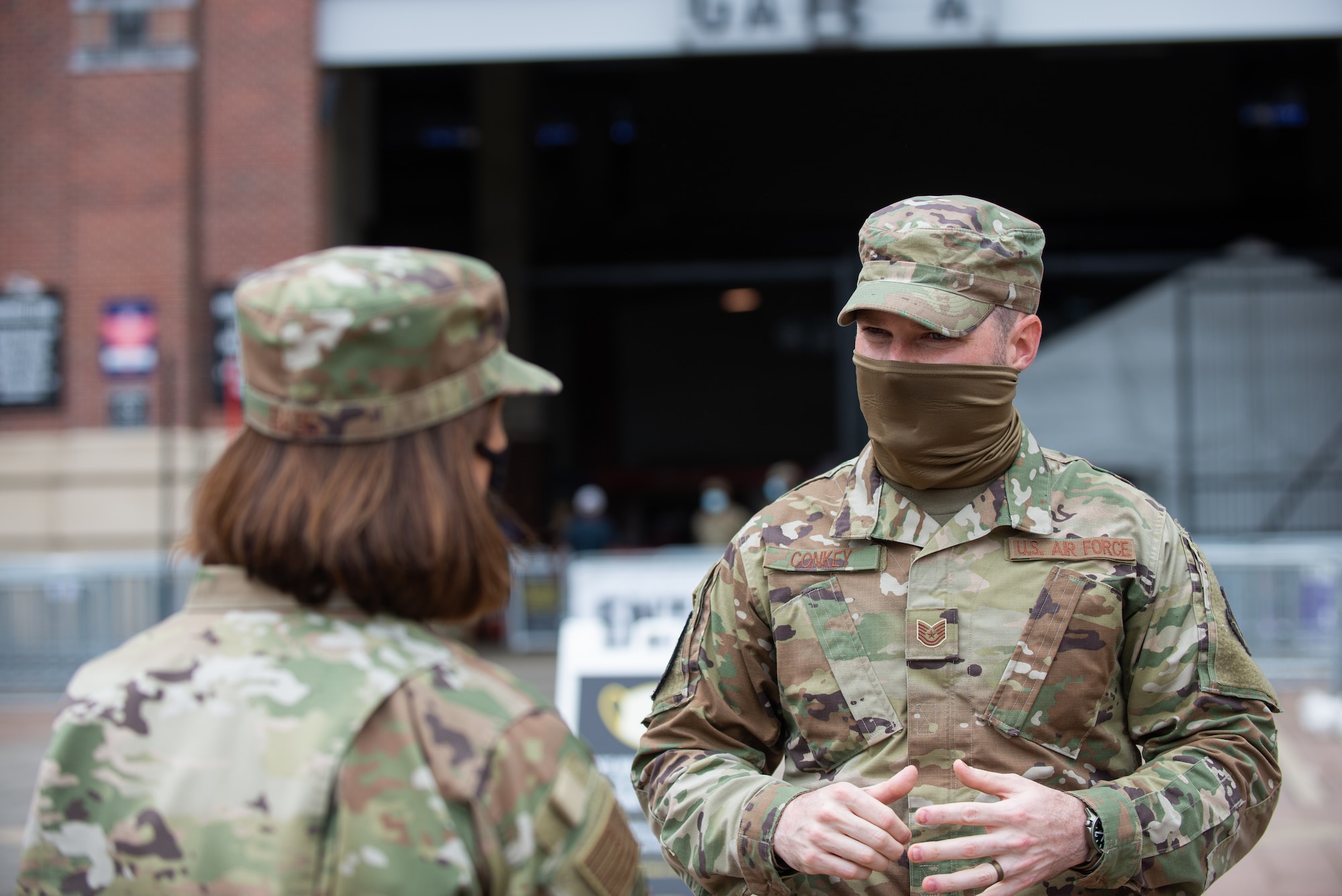 Chief Master Sgt. of the Air Force JoAnne S. Bass speaks to Tech. Sgt. Stephen Conkey, an aircrew flight equipment technician assigned to the 175th Operations Support Squadron, while visiting the mass vaccination site at M&T Bank Stadium, Baltimore, on May 3, 2021.