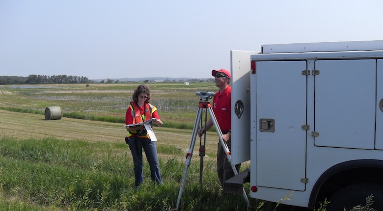Jennifer Christensen (left) and Larry Morong (retired) survey a levee bank on the Missouri River checking for low spots (levee freeboard) to determine likely areas where overtopping might occur in the event of water level rise. (Courtesy photo)